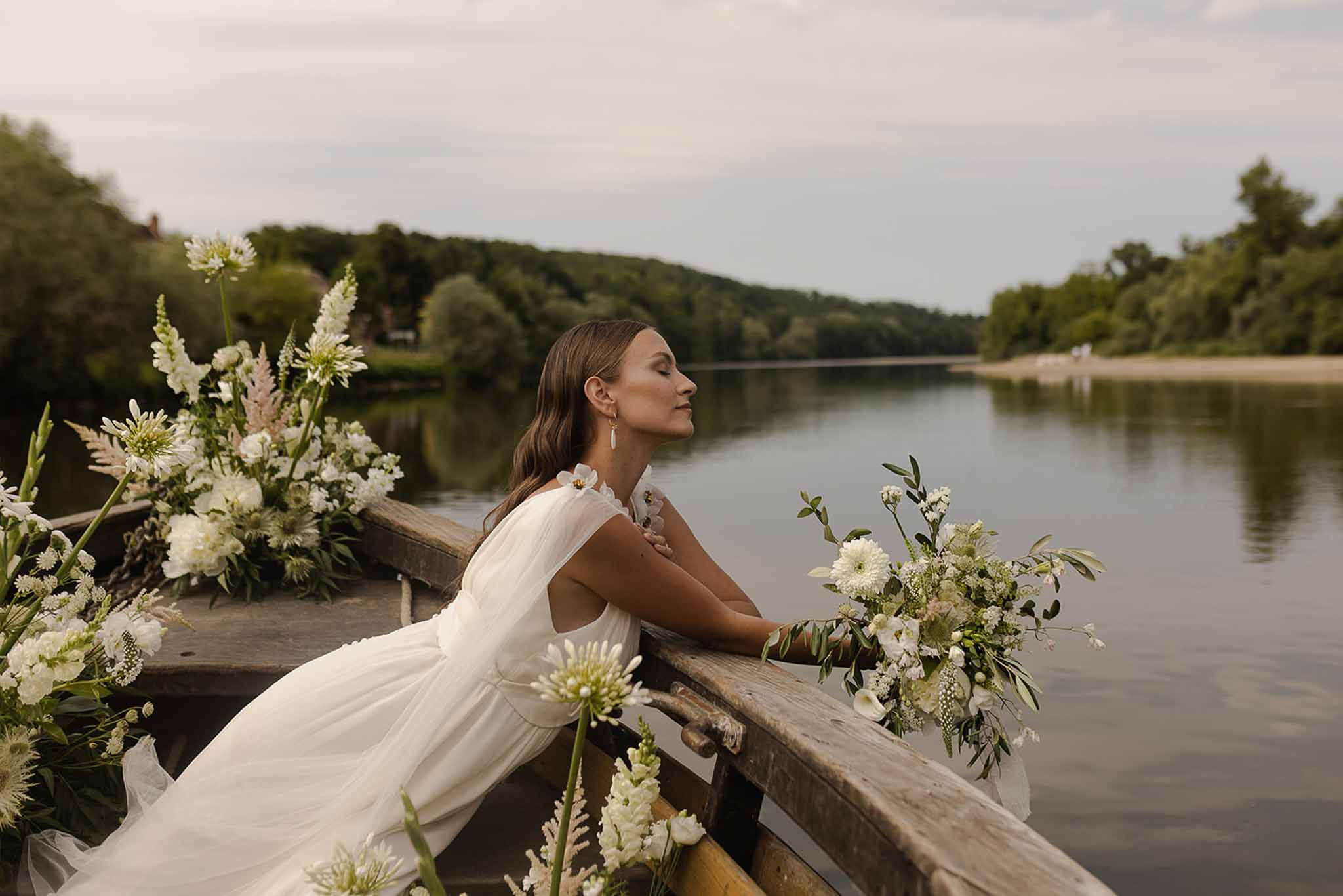 Bride in boat with wild florals on river at Plage d'Apremont-sur-Allier Burgundy