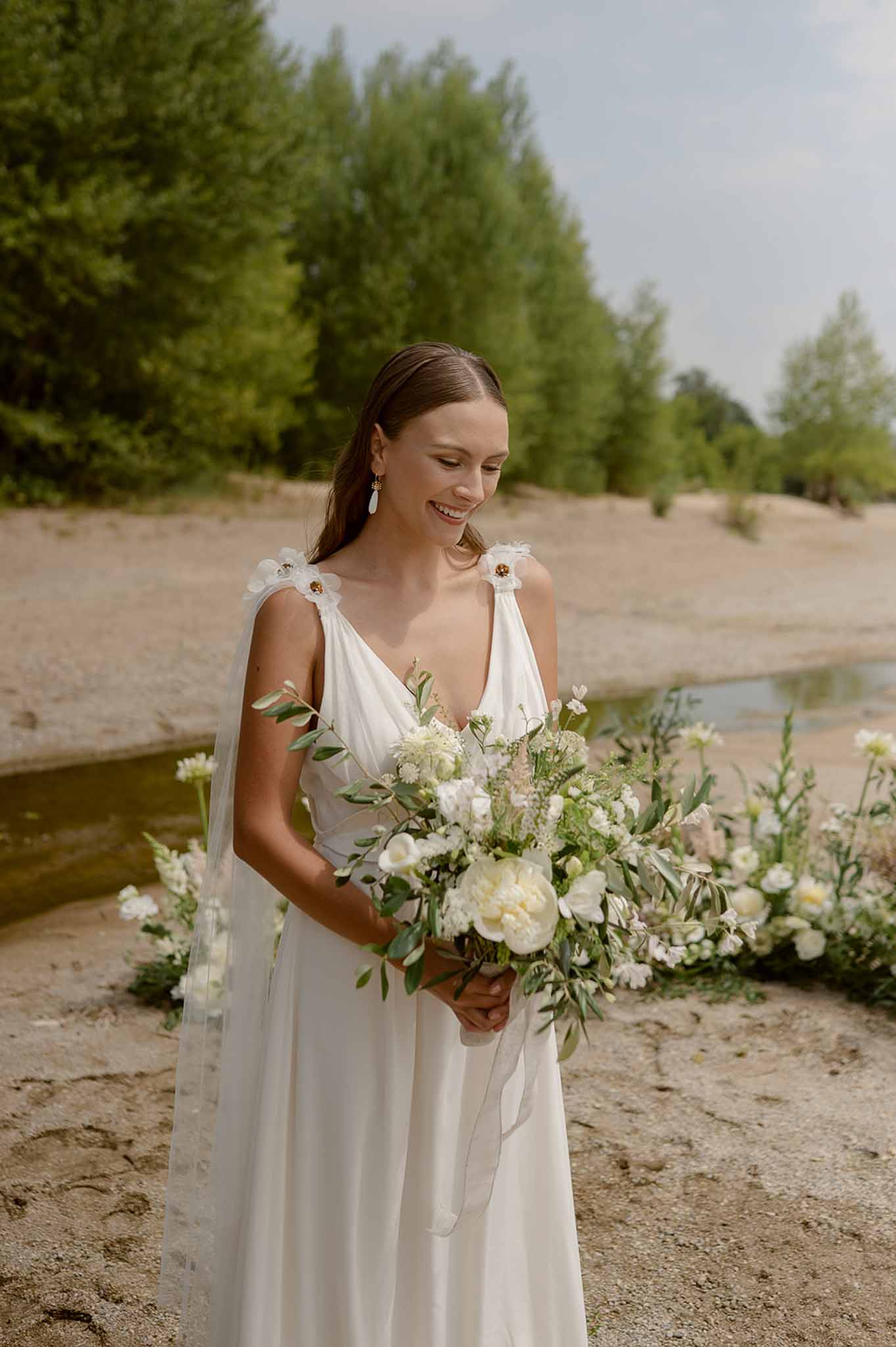 Bride with white bouquet on sandy riverbank at Plage d'Apremont-sur-Allier
