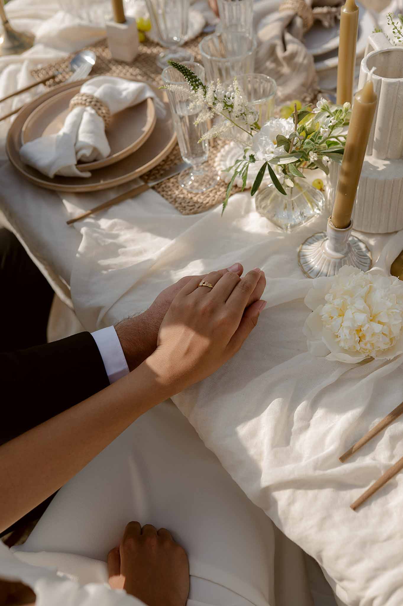 Couple's hands with rings at reception table at Plage d'Apremont-sur-Allier