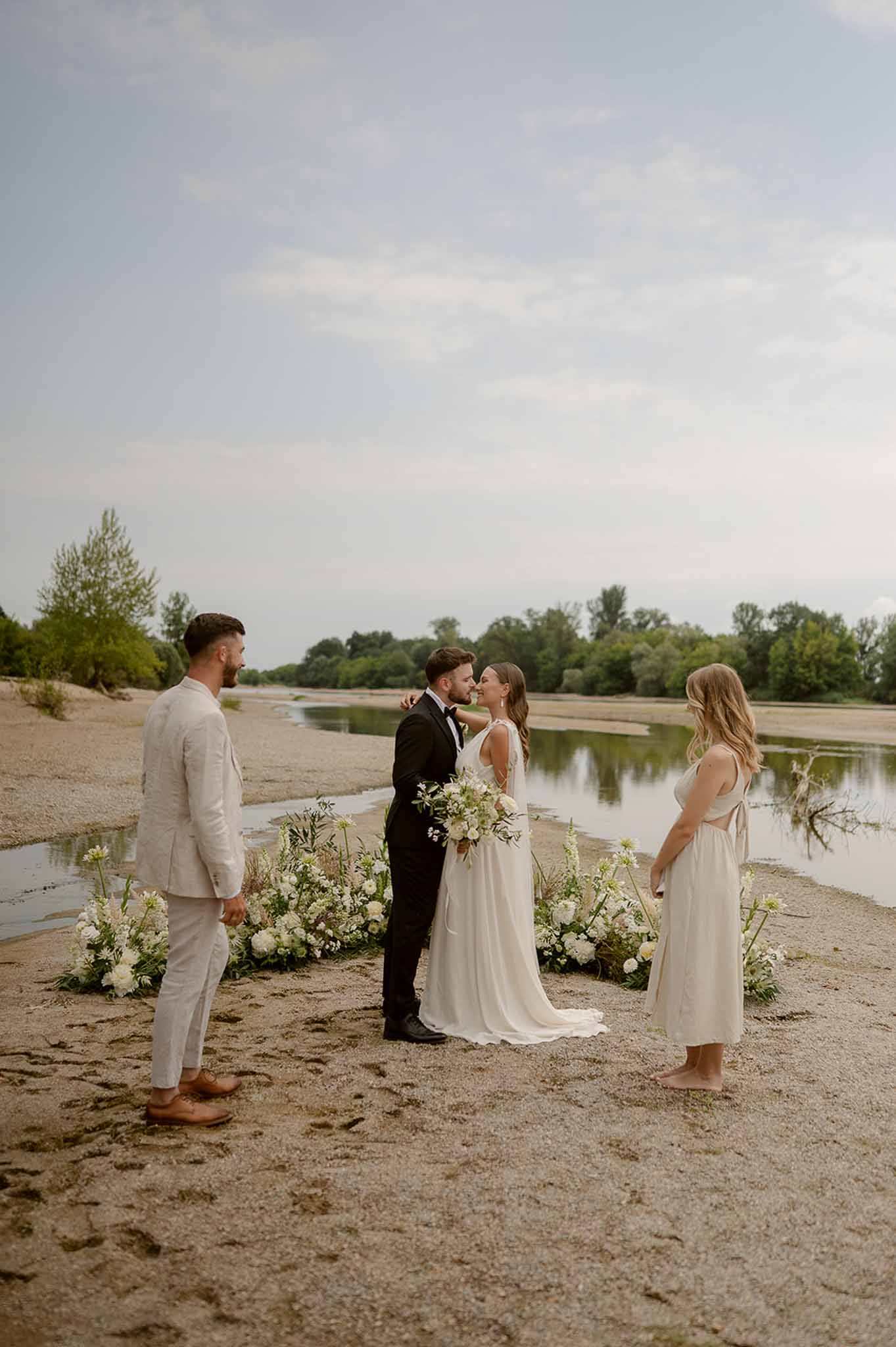 First kiss at riverside ceremony with wildflowers at Plage d'Apremont-sur-Allier
