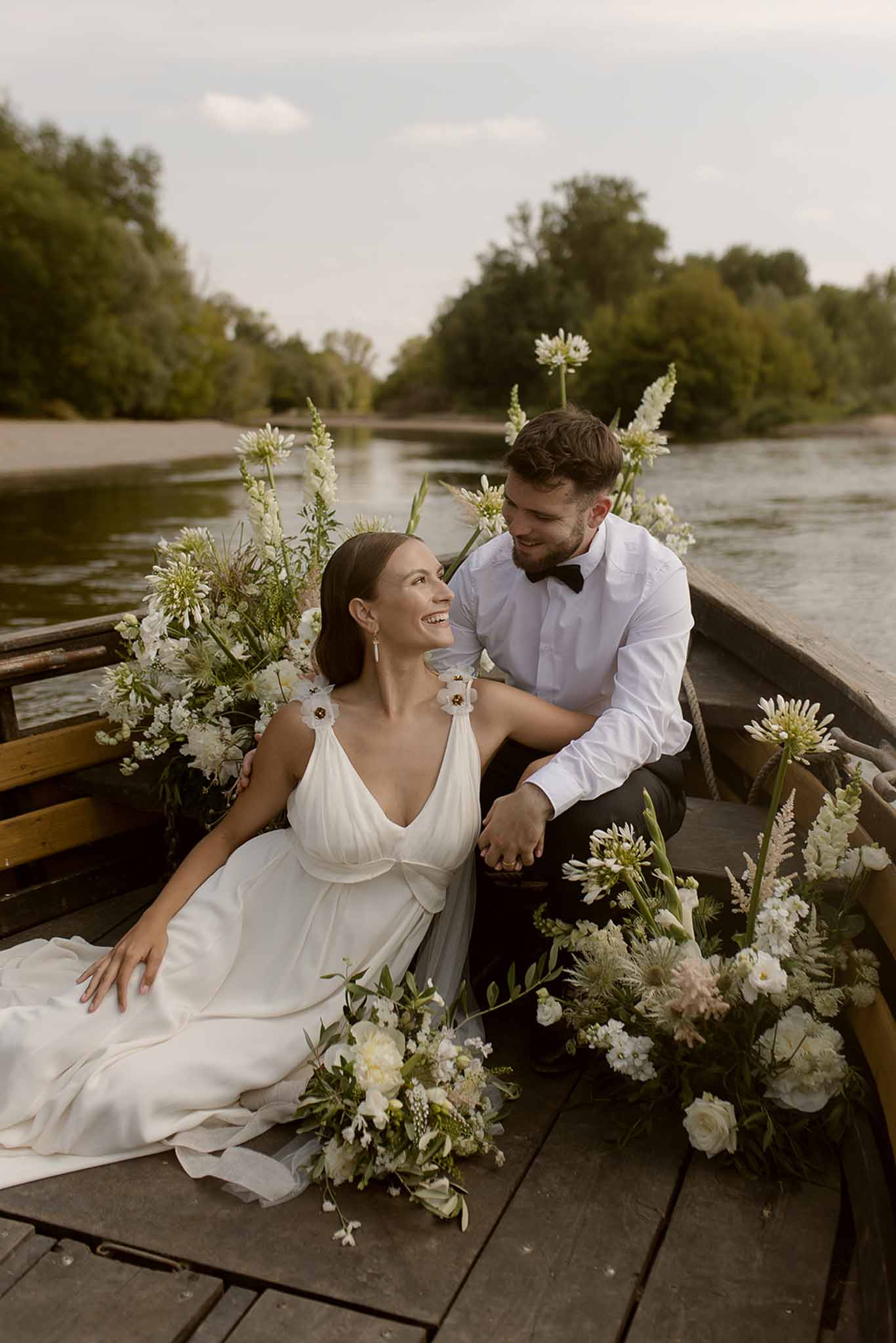 Couple laughing in flower-filled boat at Plage d'Apremont-sur-Allier Burgundy