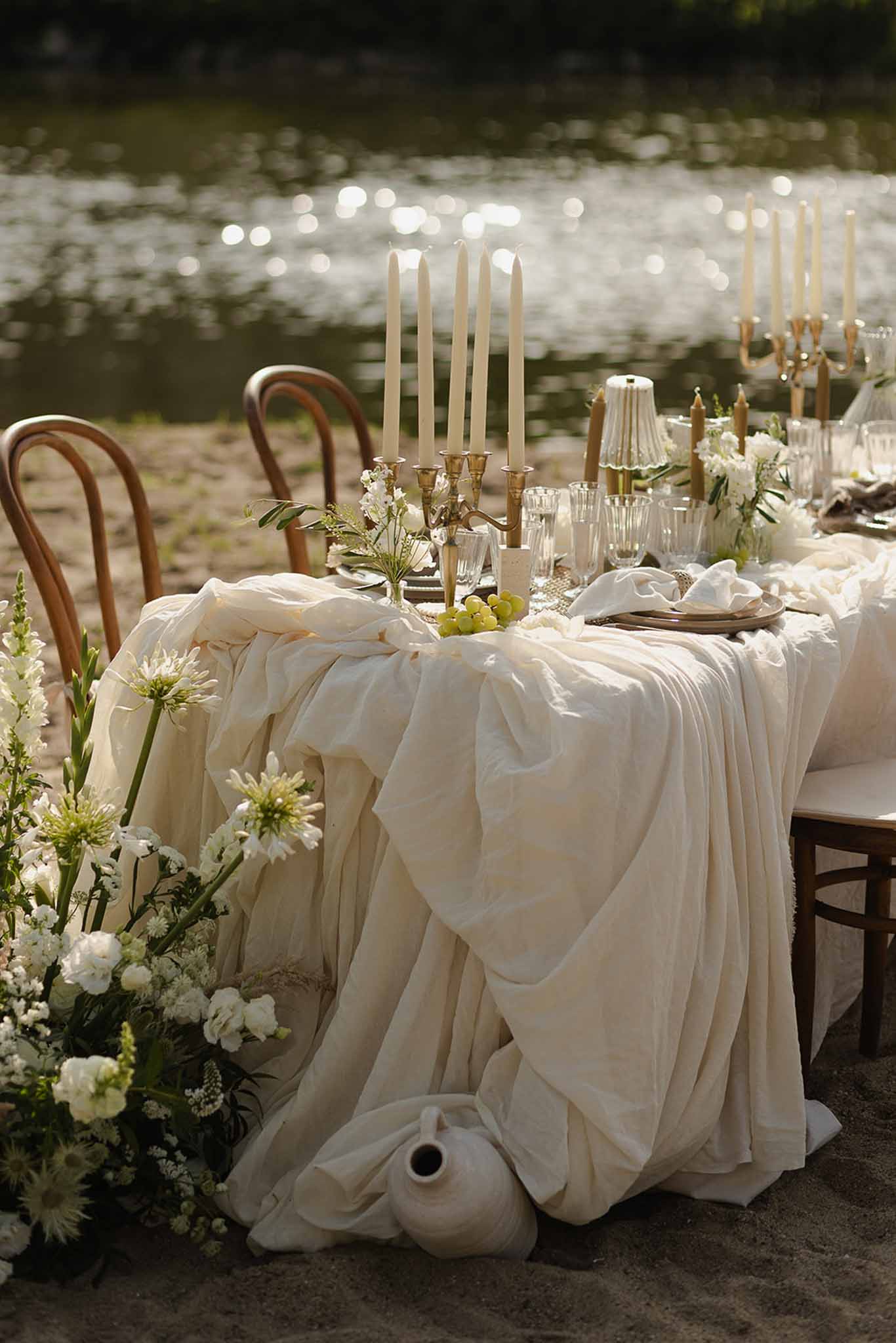 Draped linen and gold candles by river at Plage d'Apremont-sur-Allier reception
