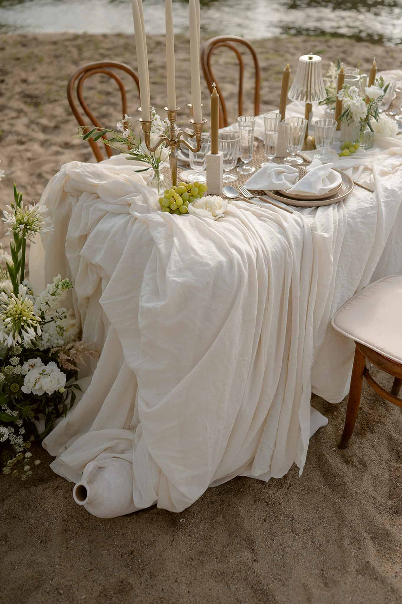End-on tablescape with cascading linen and bentwood chairs at Plage d'Apremont-sur-Allier