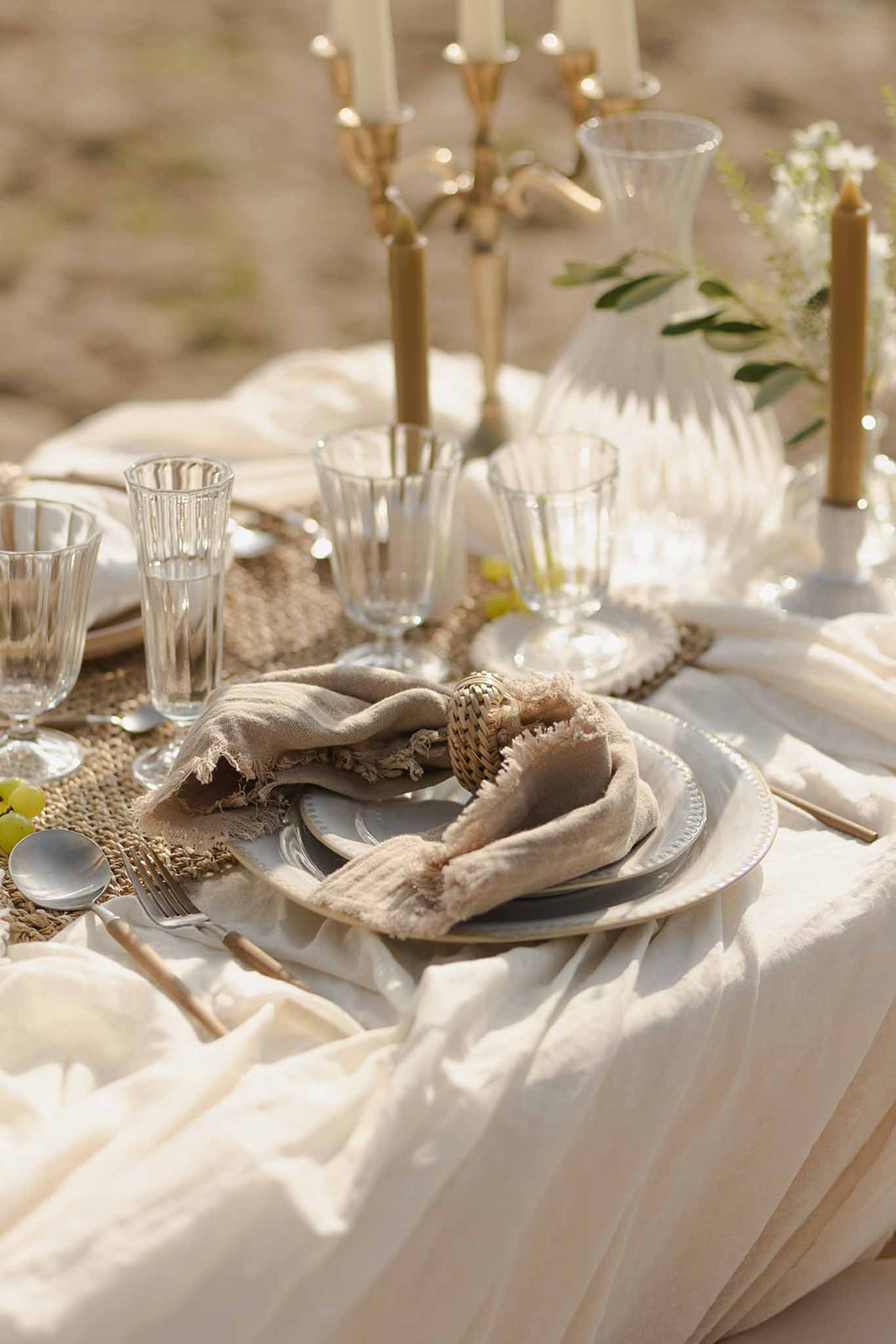 Place setting with linen napkin and gold candles at Plage d'Apremont-sur-Allier