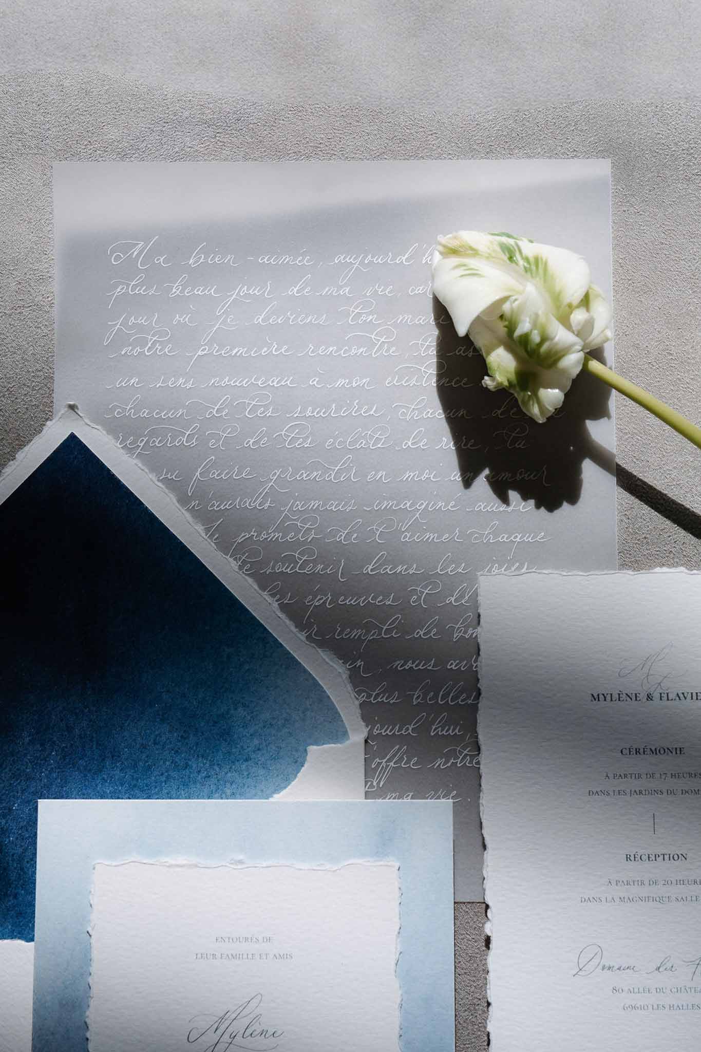 Navy and pale blue French calligraphy stationery suite with vellum love letter and white ranunculus