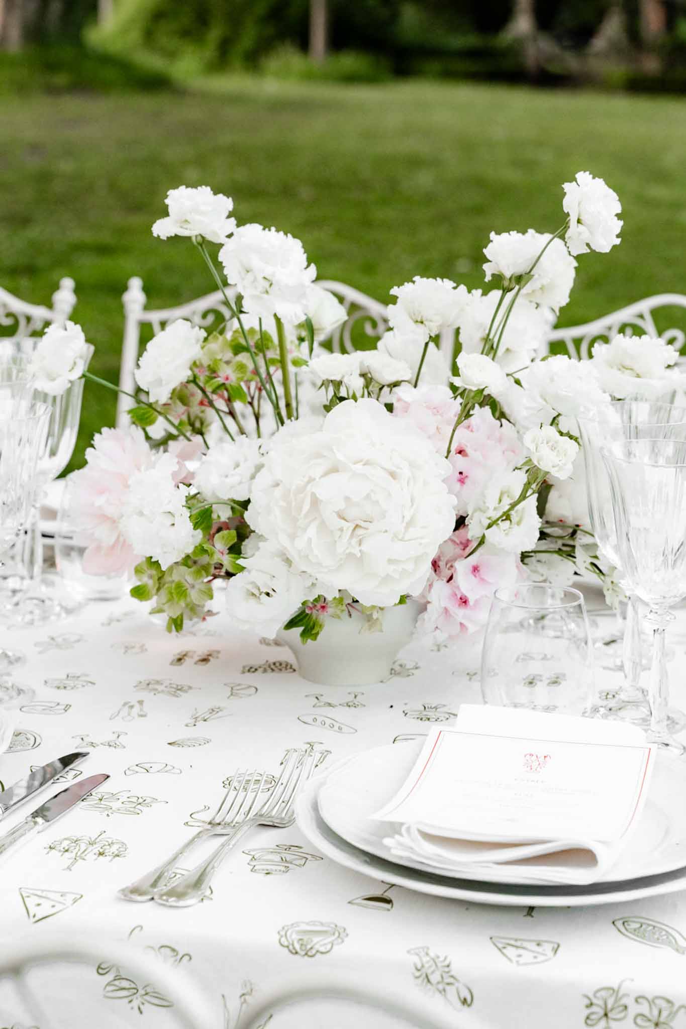 Wedding reception table setting in a garden with peonies