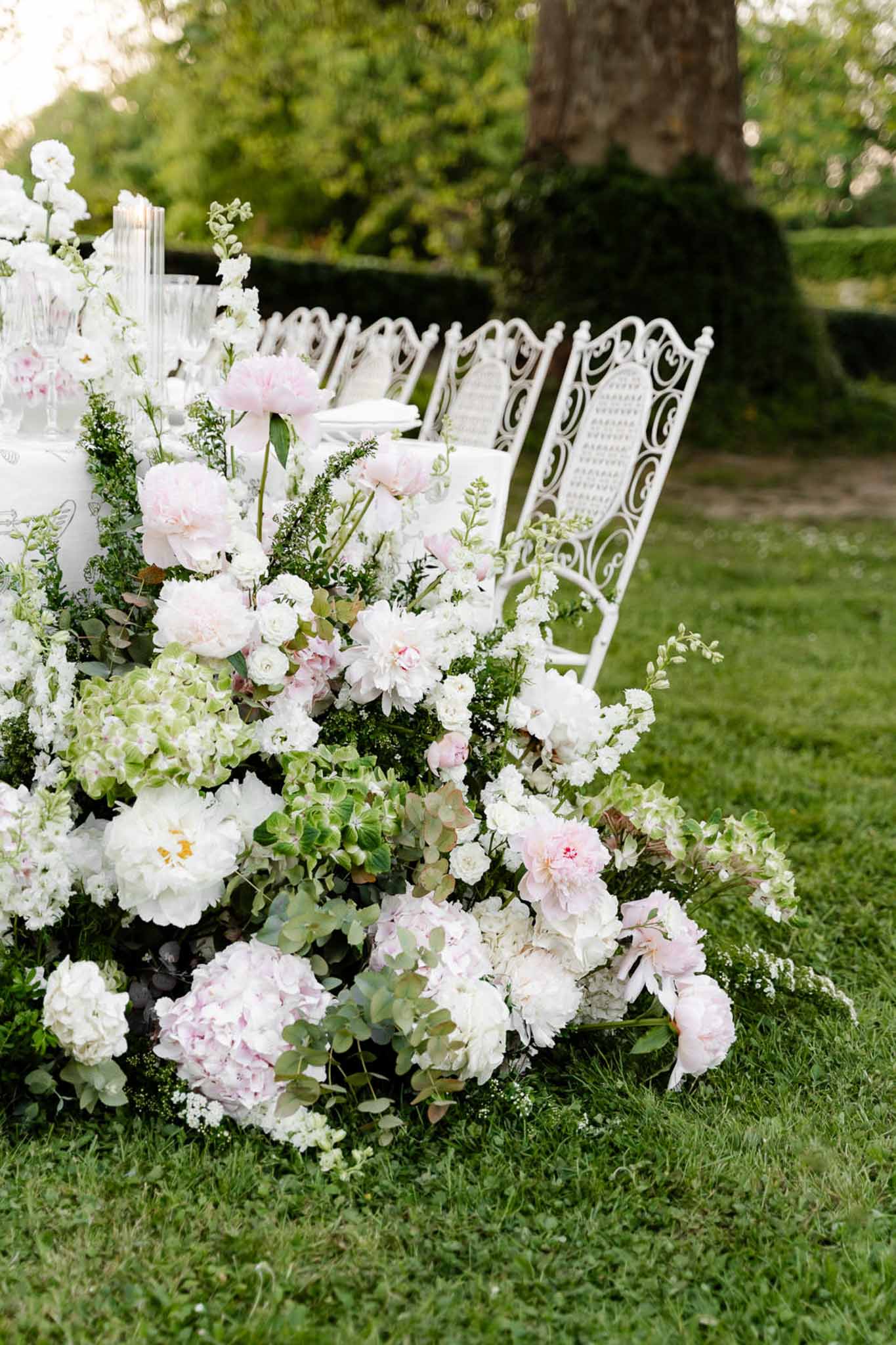 Wedding reception table setting in a garden with white roses