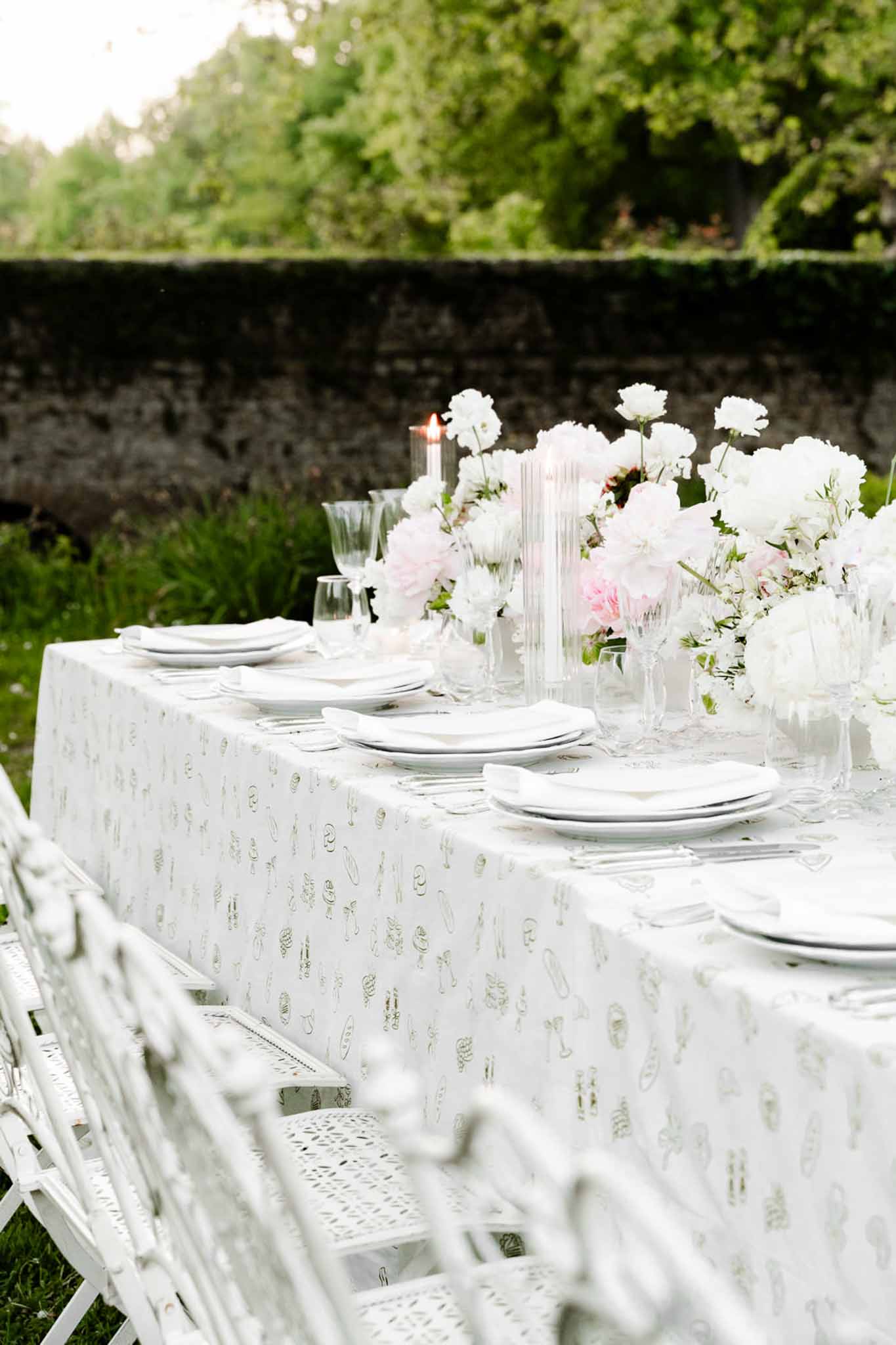 Wedding reception table setting in a garden with peonies