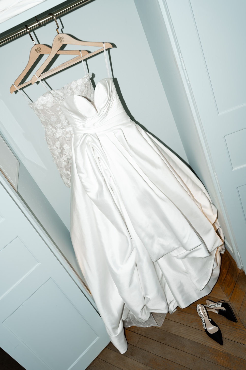 Strapless pleated ballgown and lace dress on fleur-de-lis hangers with nude and black heels beneath
