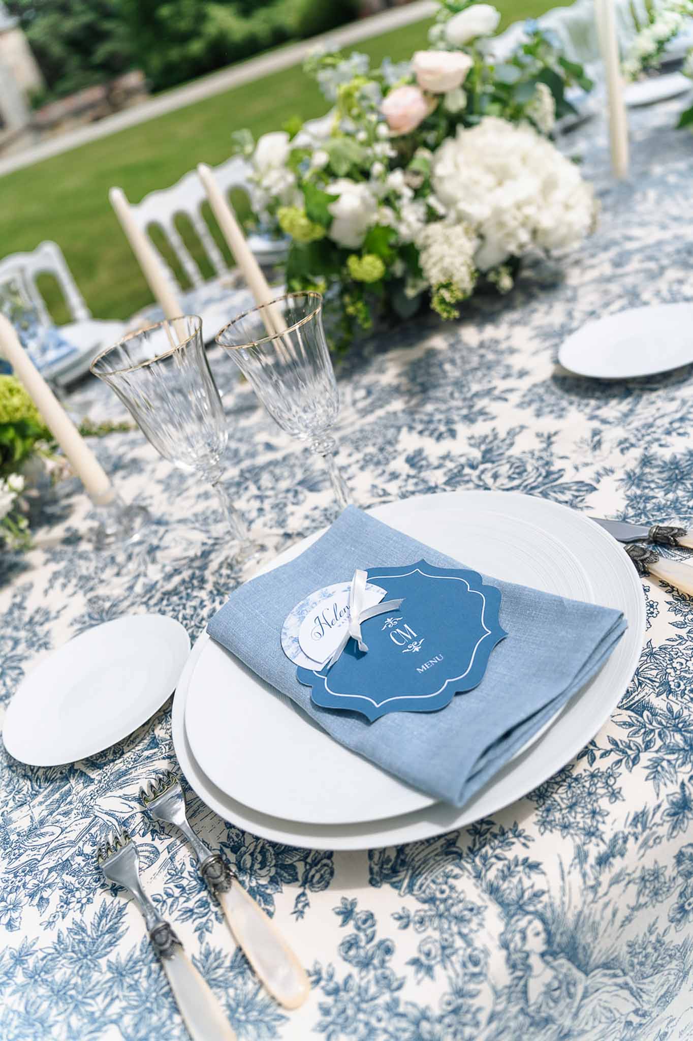Toile table setting with navy menu card monogram crest white hydrangea and blush rose centerpiece
