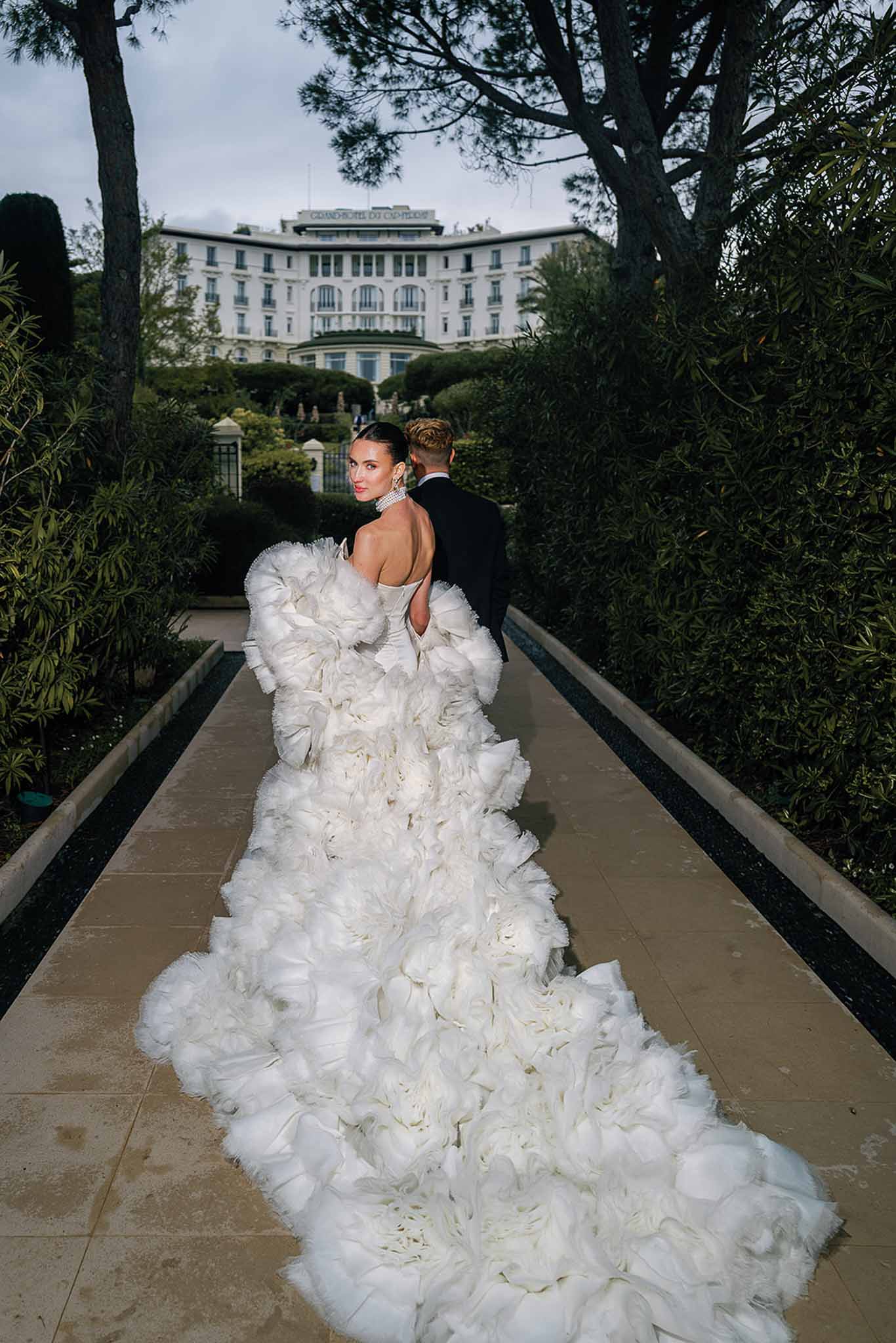 Bride and groom walking hand in hand in a garden