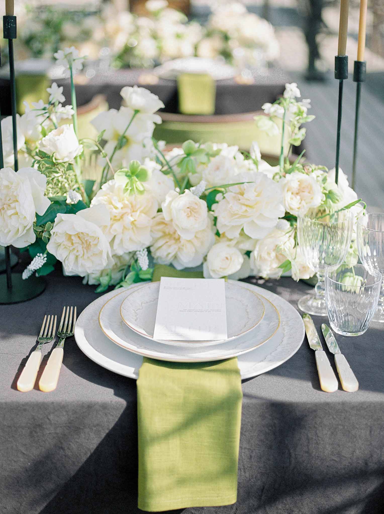 Wedding reception table setting in a garden with white roses