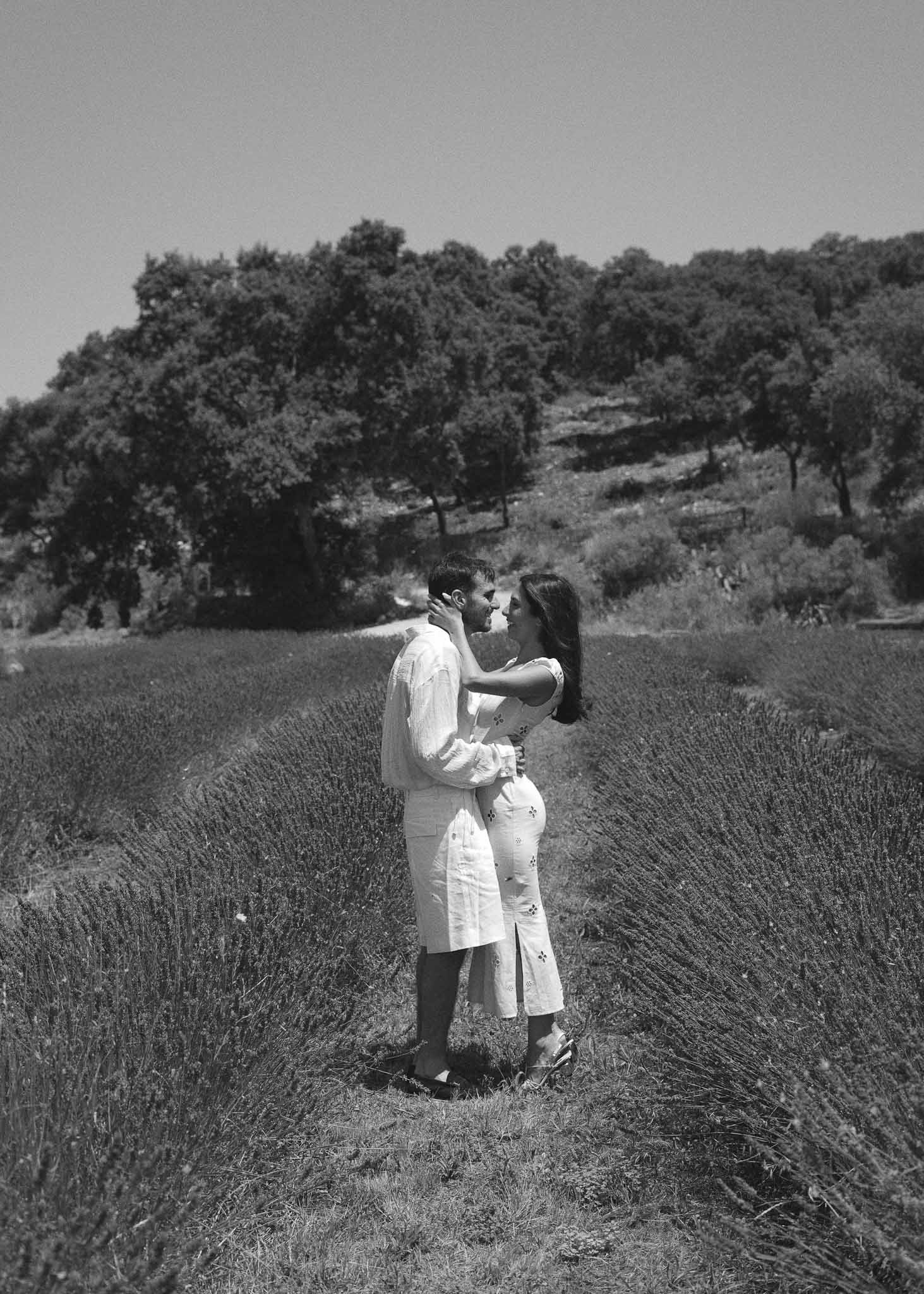 Black and white couple about to kiss in lavender field rows wearing matching white linen outfits
