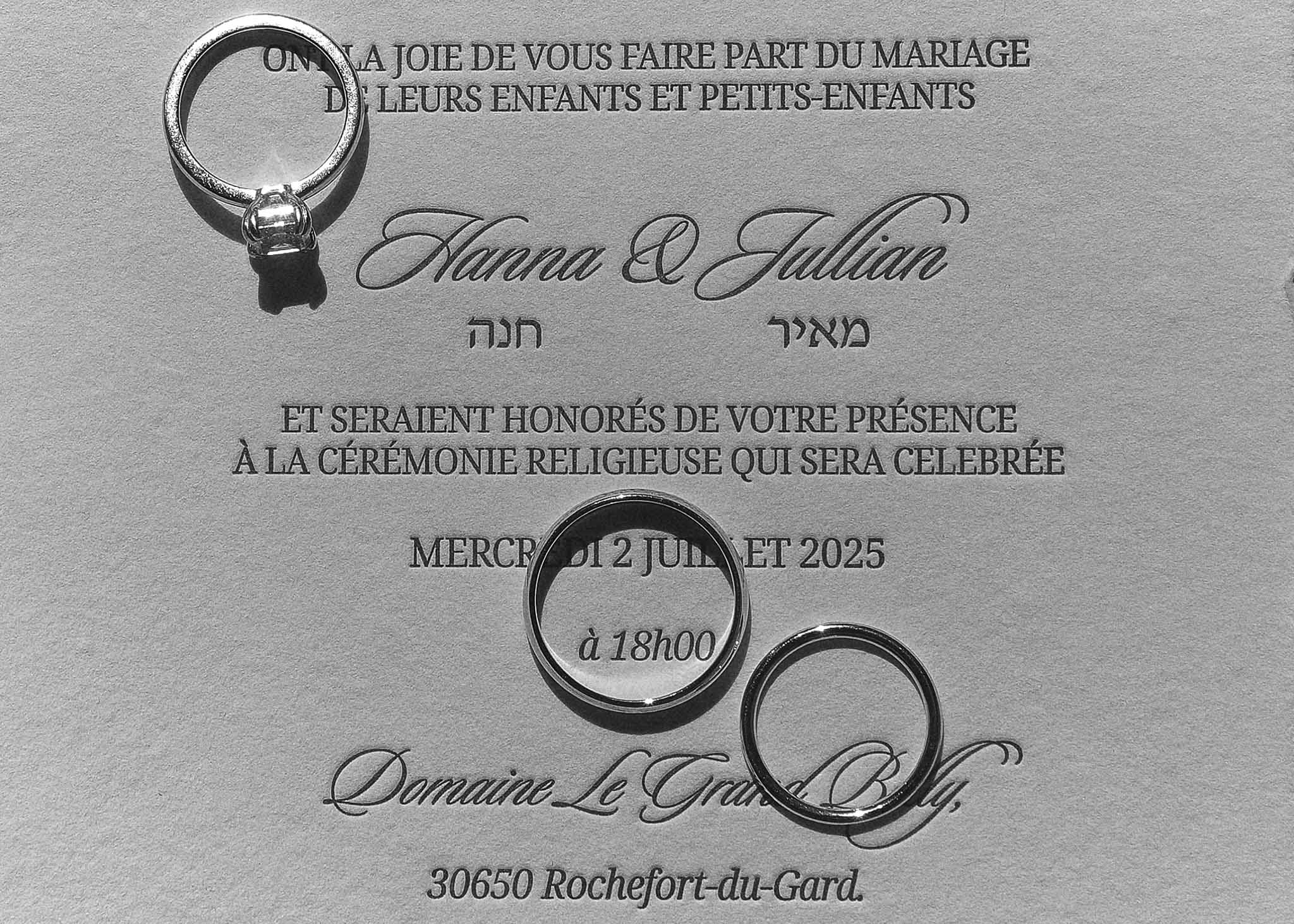 French-Hebrew wedding invitation with diamond solitaire and two plain bands on card in B&W close-up