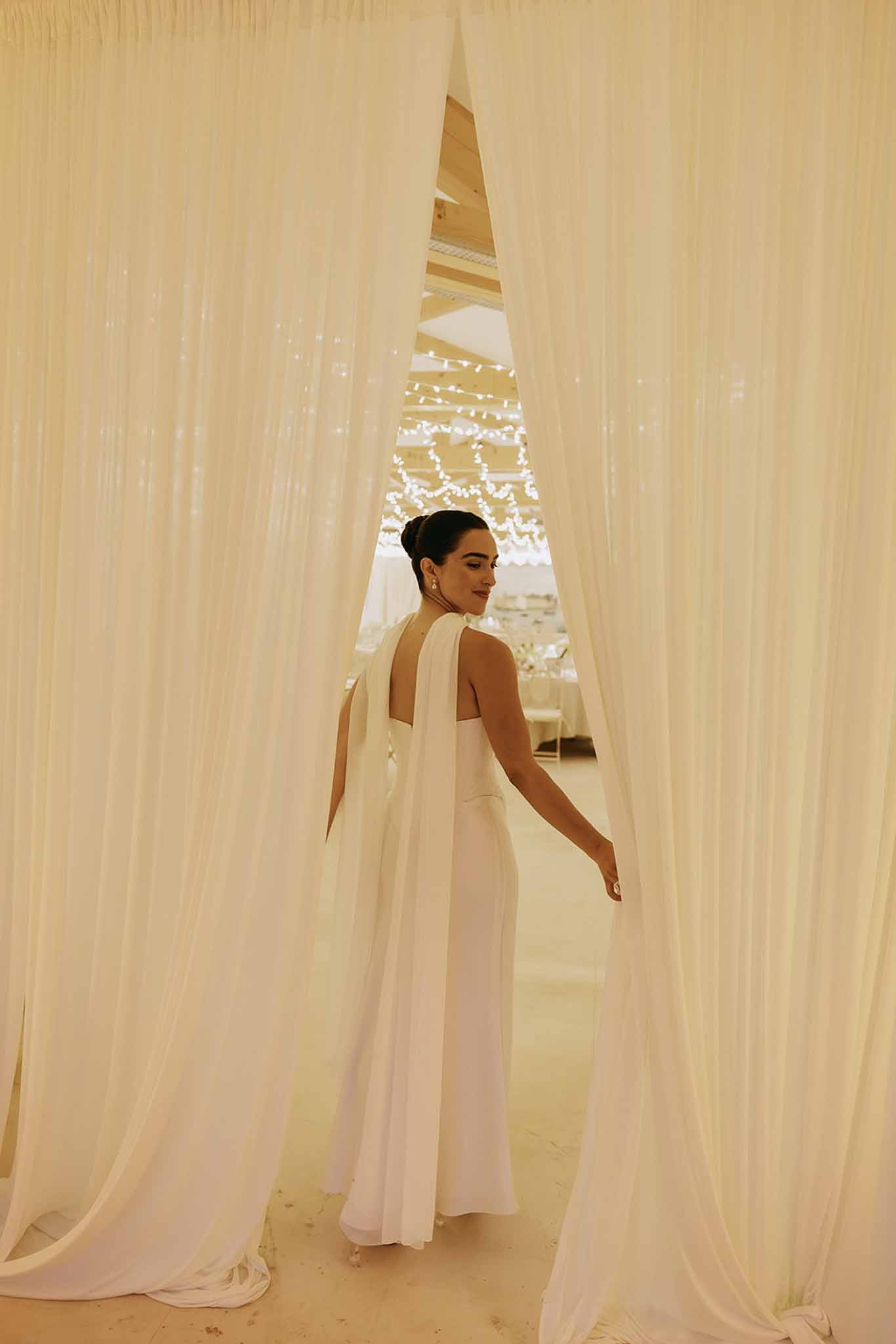 Bride in second look with silk shawl behind curtains at Domaine Rocabella, Cote d'Azur