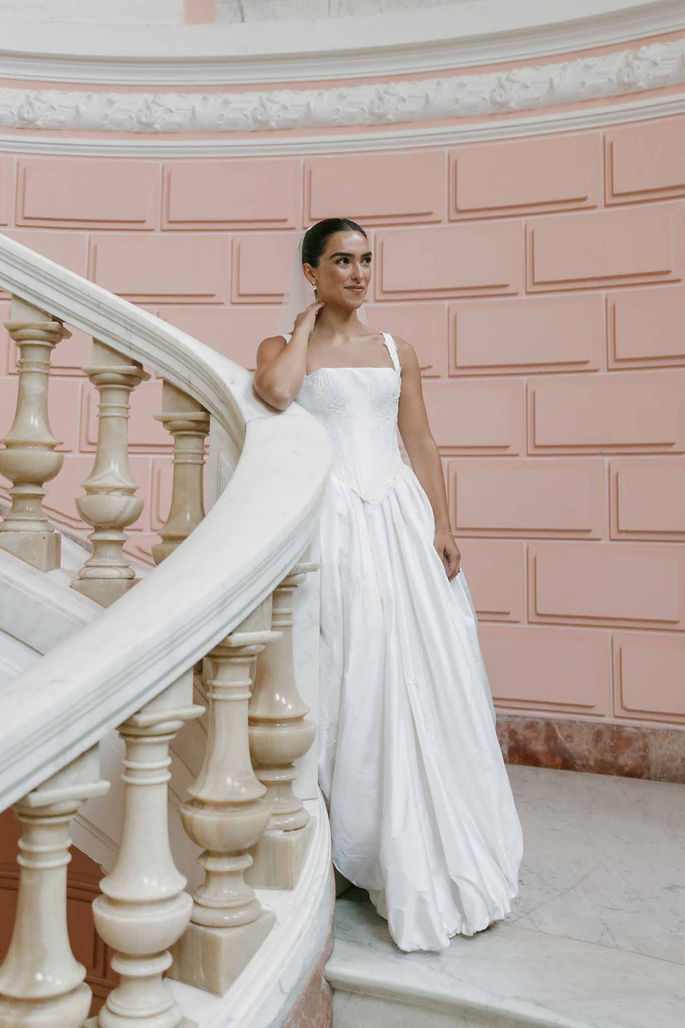 Bride on pink marble staircase with veil at Domaine Rocabella, Cote d'Azur