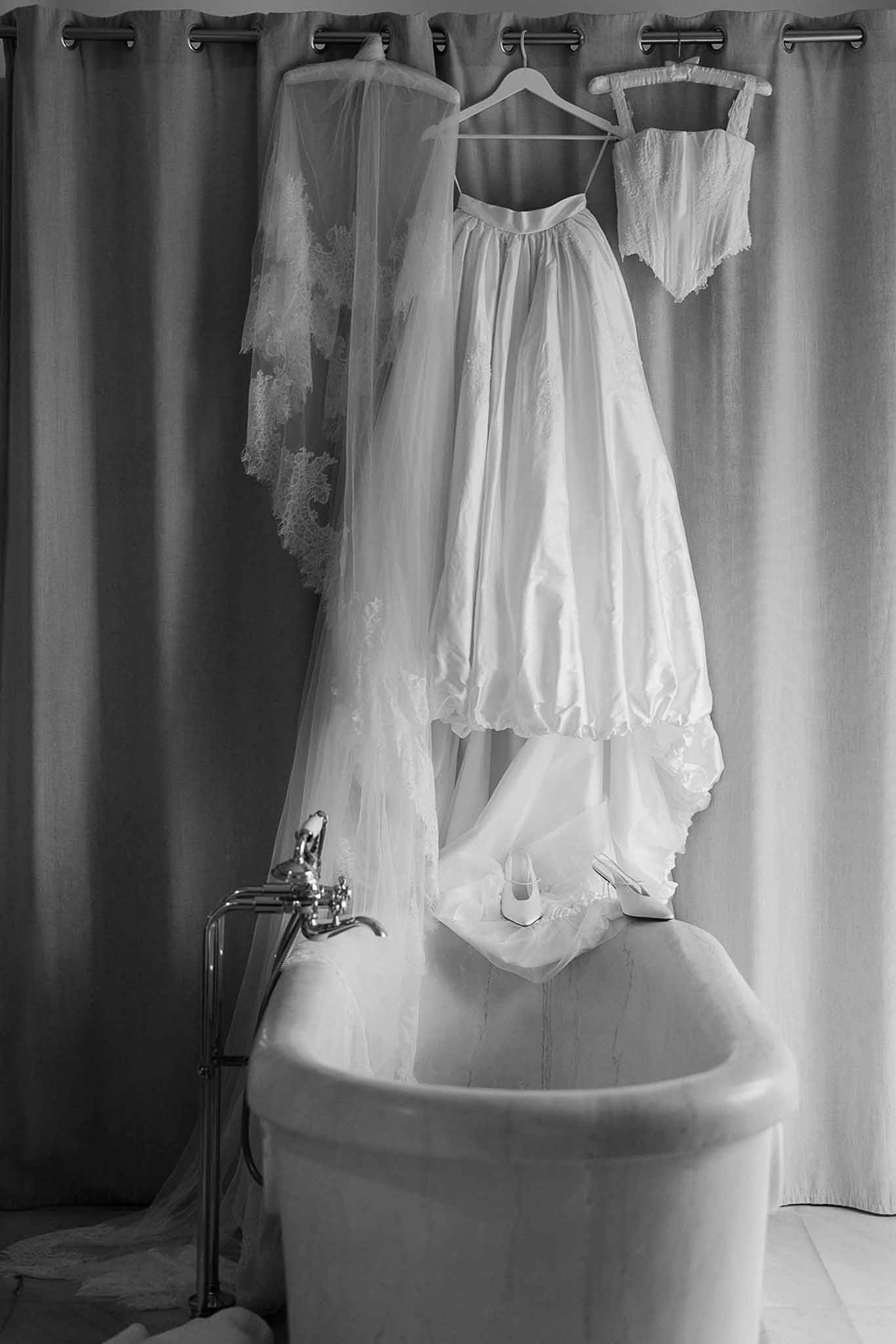 Wedding dress and veil hanging above bathtub at Domaine Rocabella, Cote d'Azur