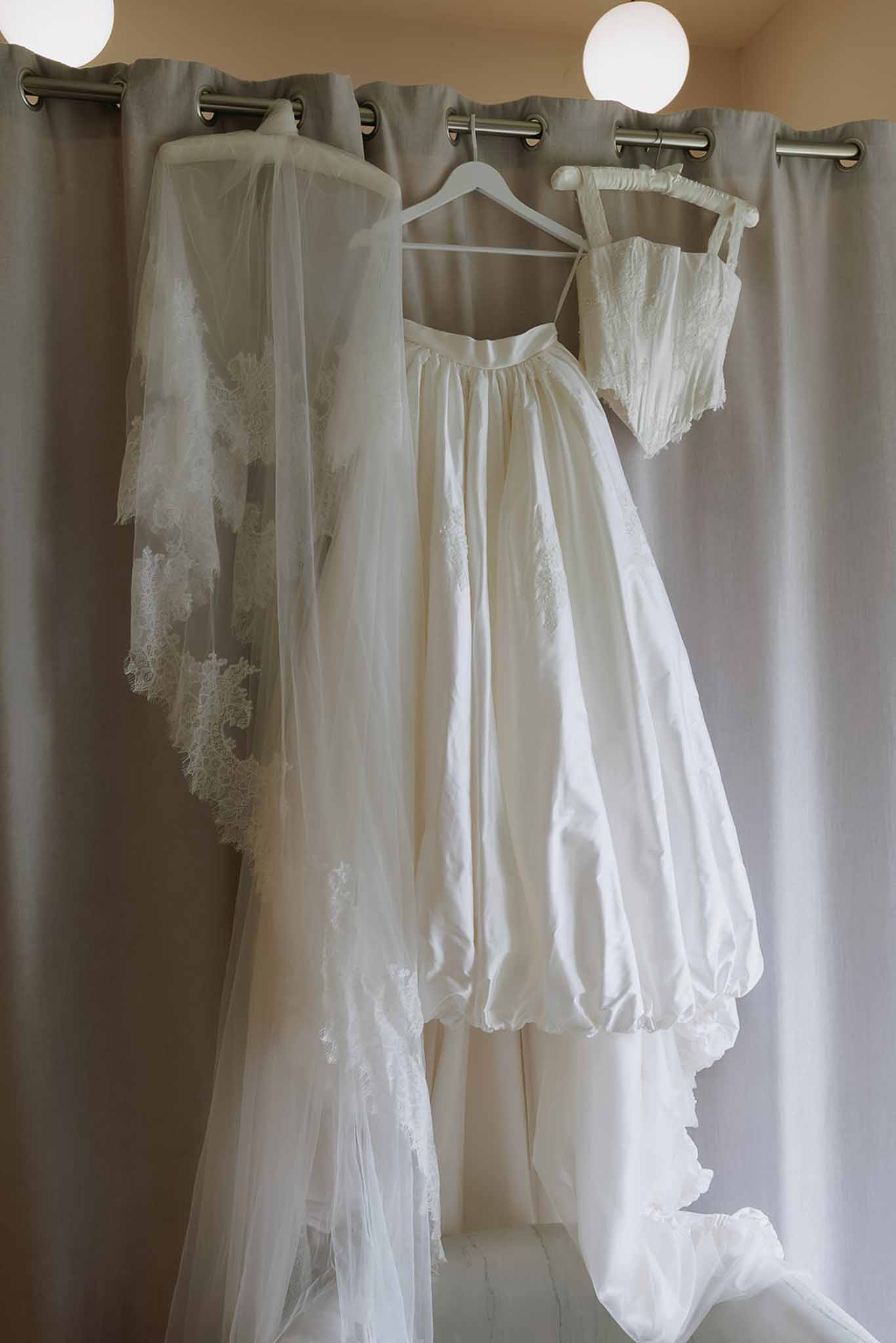 Two-piece wedding dress and cathedral veil hanging at Domaine Rocabella, Cote d'Azur