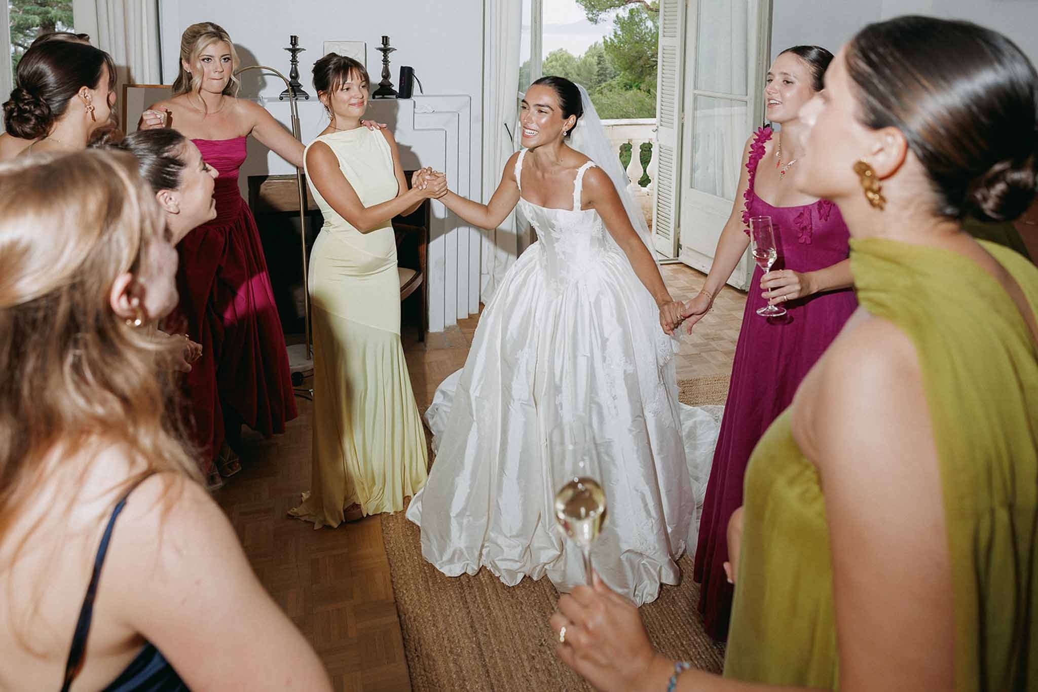 Bride dancing with bridesmaids in colourful gowns at Domaine Rocabella, Cote d'Azur