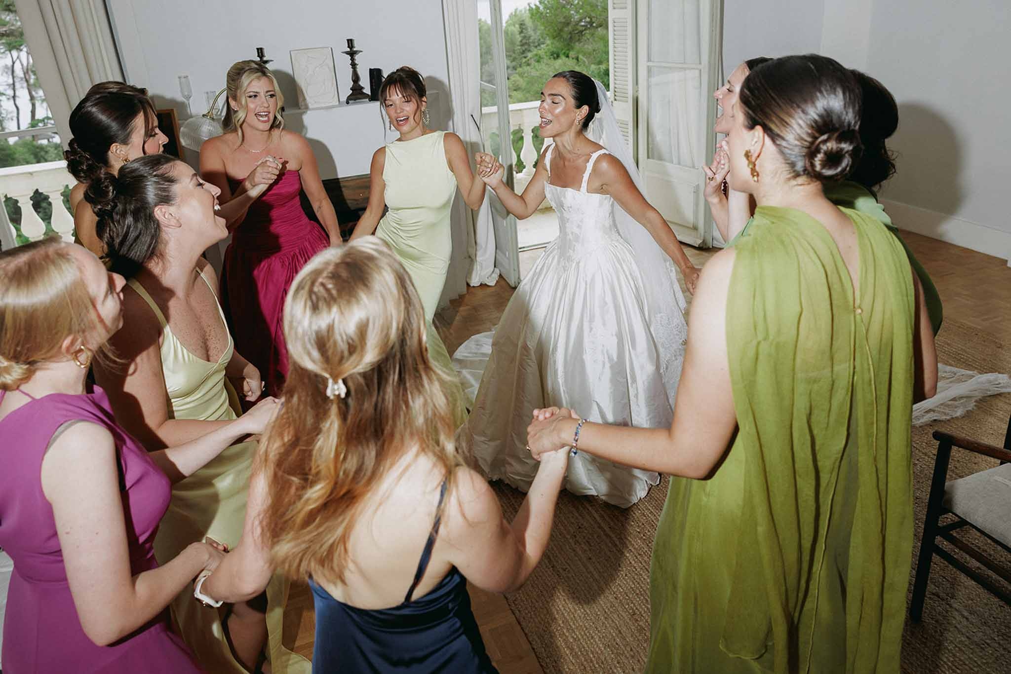 Bride dancing in circle with bridesmaids at Domaine Rocabella, Cote d'Azur