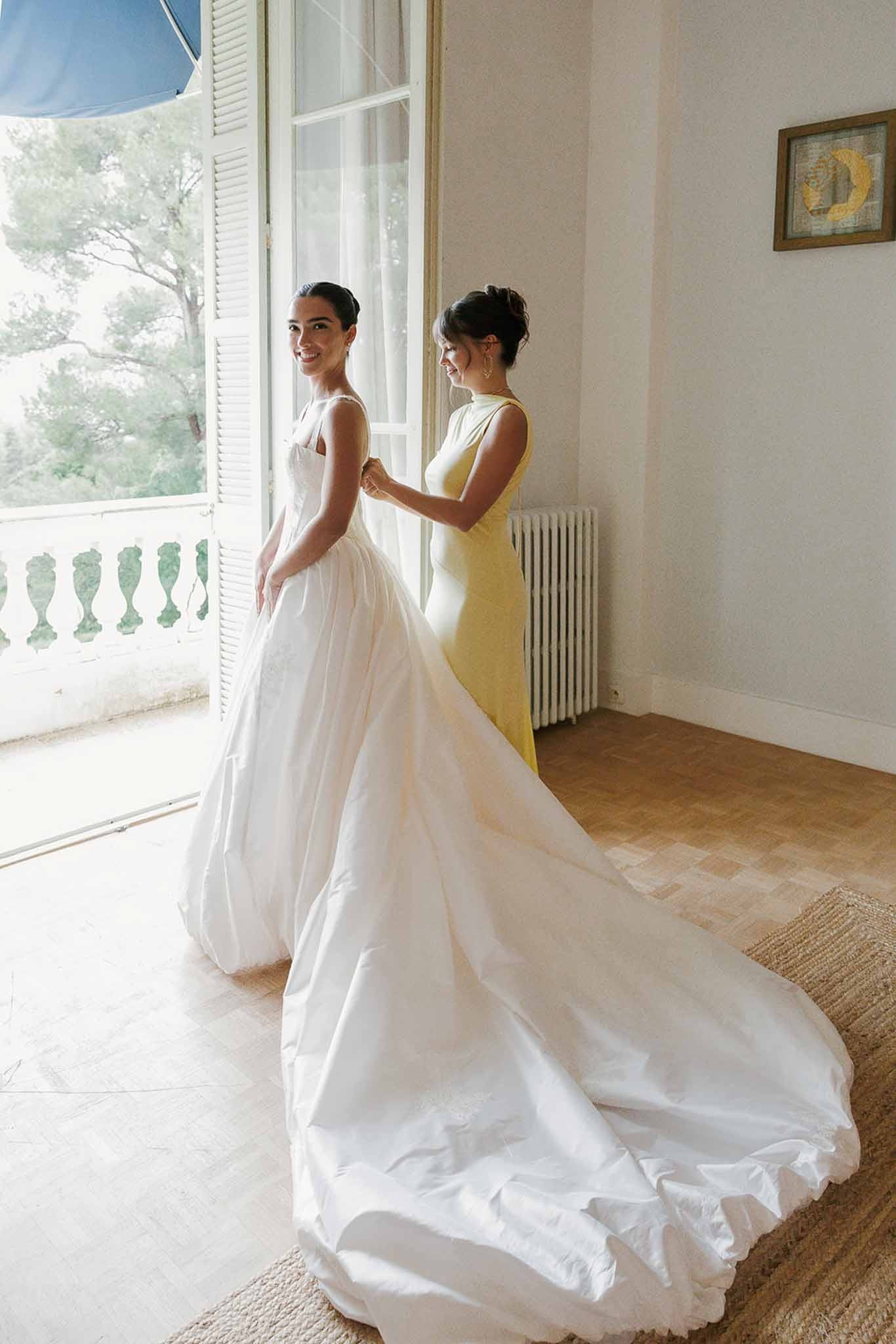 Bridesmaid fastening bride's corset at Domaine Rocabella, Cote d'Azur