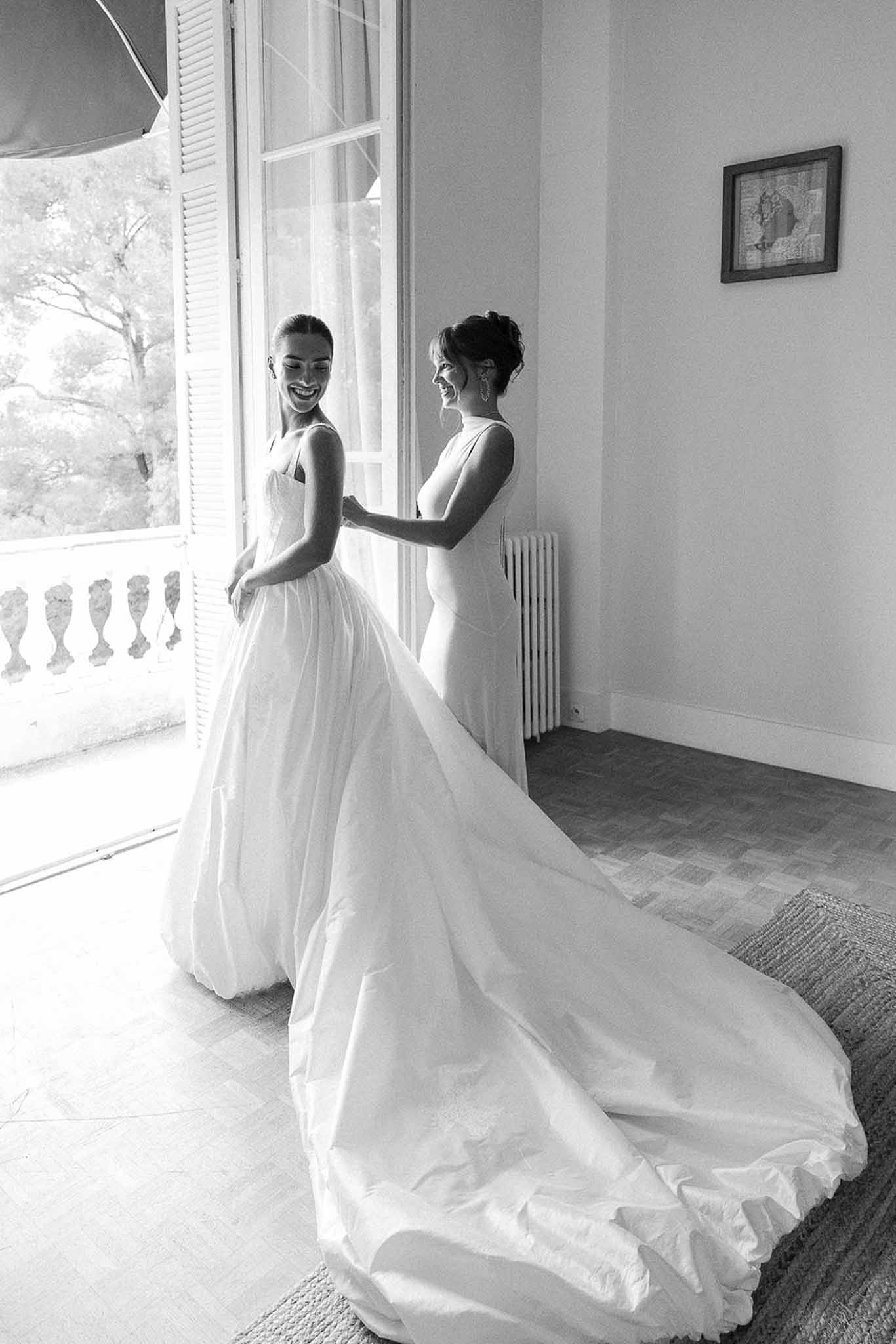 Bride being laced into corset bodice at Domaine Rocabella, Cote d'Azur