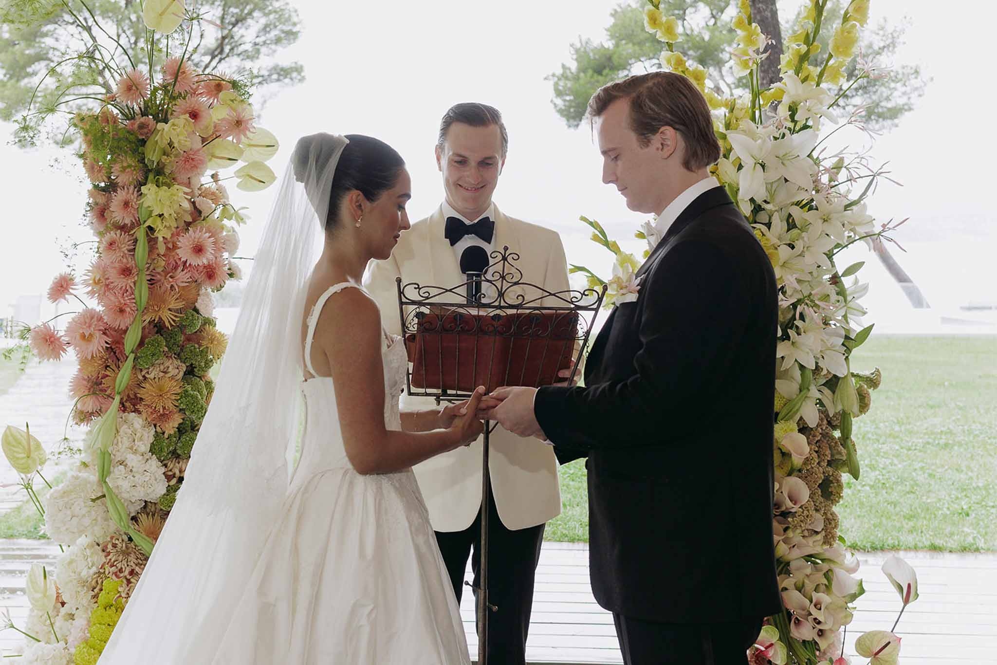 Couple exchanging rings under floral arch at Domaine Rocabella, Cote d'Azur