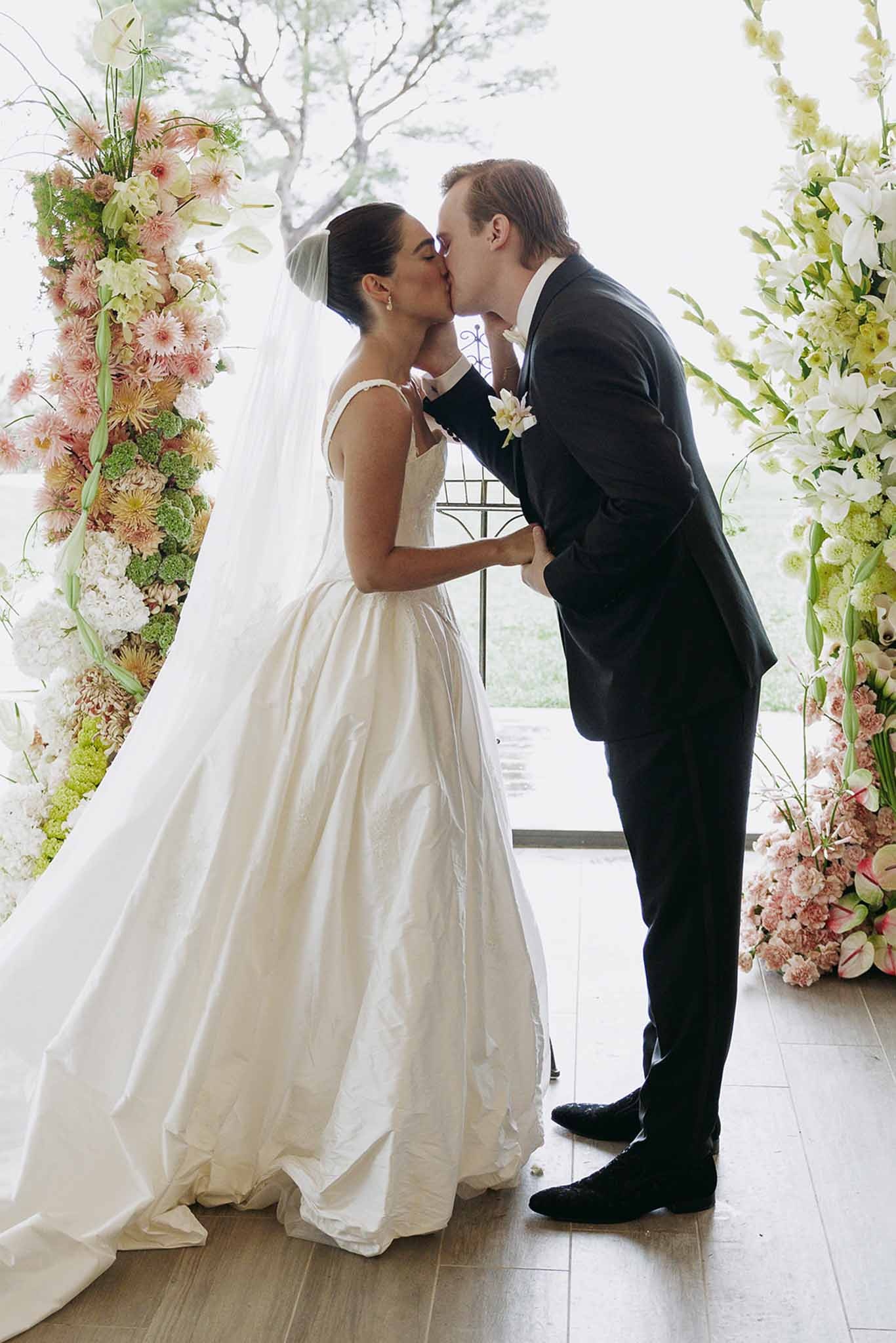 First kiss under floral arch ceremony at Domaine Rocabella, Cote d'Azur