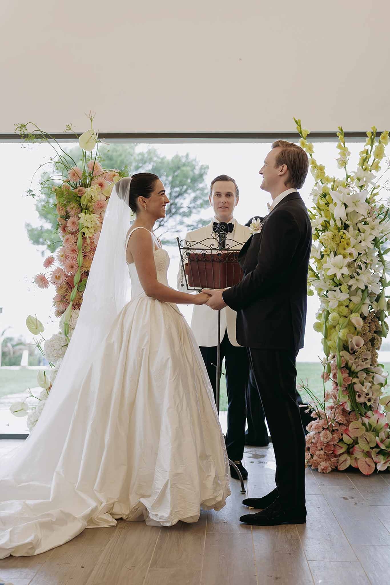 Couple at altar with officiant and floral arch at Domaine Rocabella, Cote d'Azur