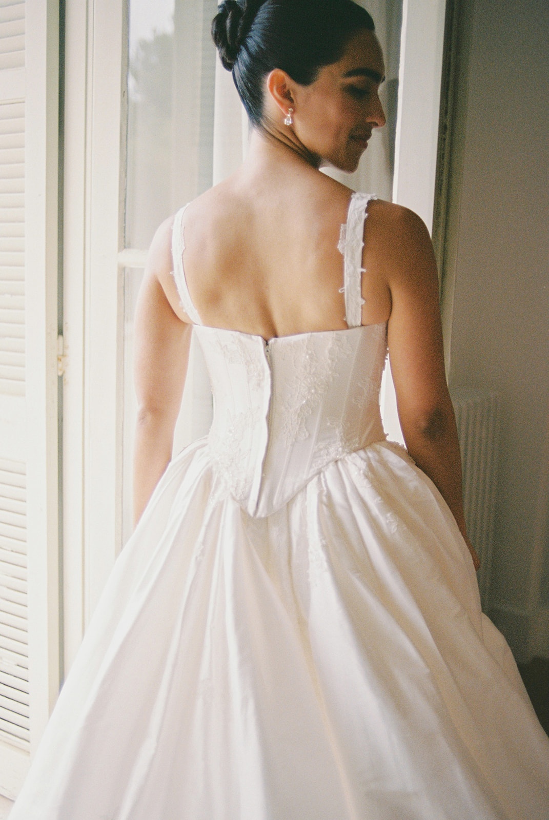 Bridal gown back detail by window at Domaine Rocabella