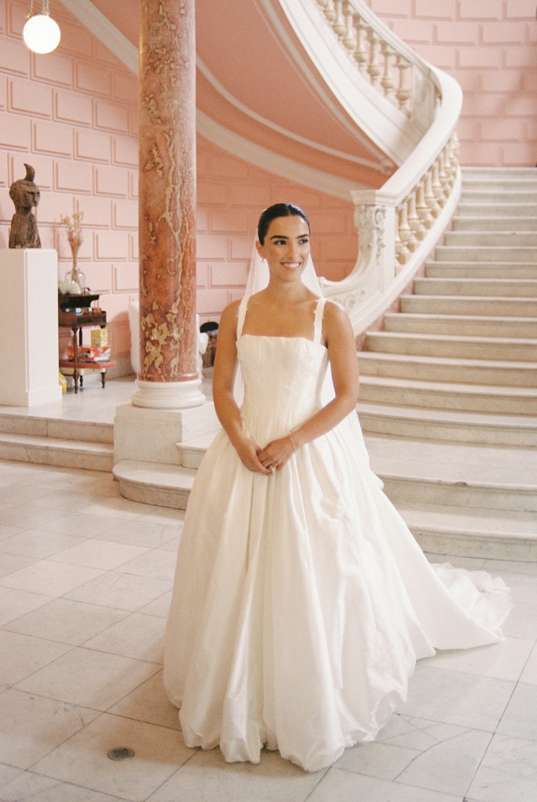 Bride in pink marble hall with staircase at Domaine Rocabella