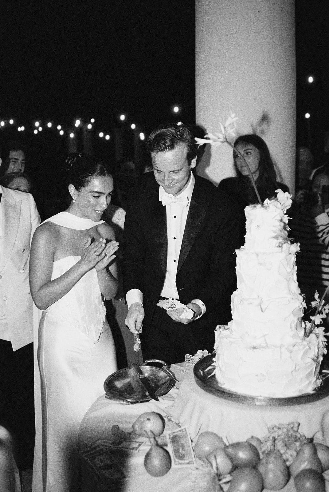 Couple cutting wedding cake at night at Domaine Rocabella