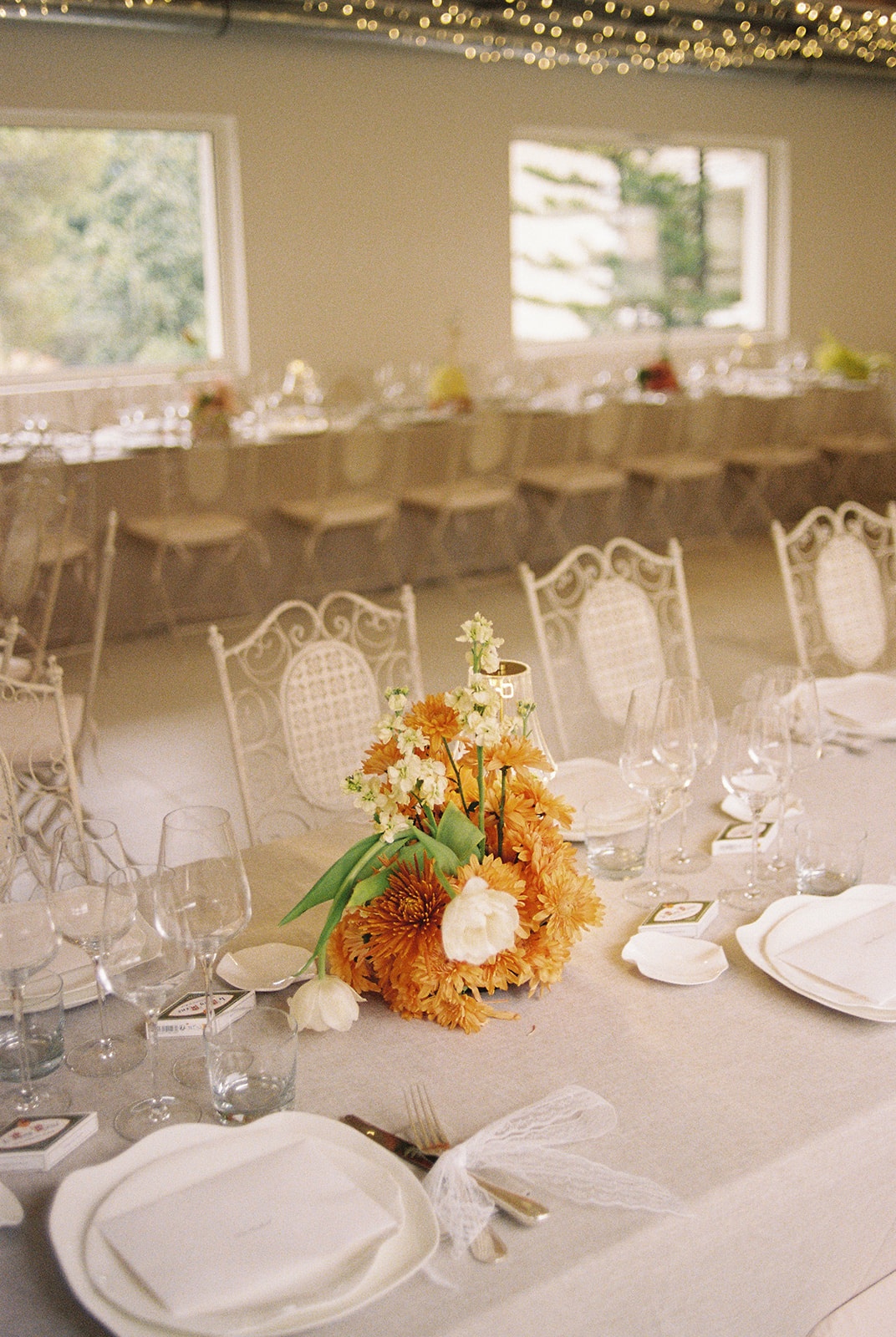 Reception table with amber floral centrepiece at Domaine Rocabella