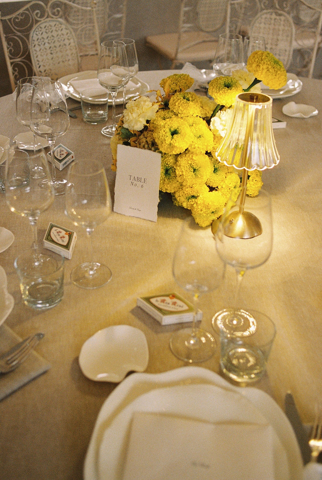 Place setting with yellow flowers and gold lamp at Domaine Rocabella