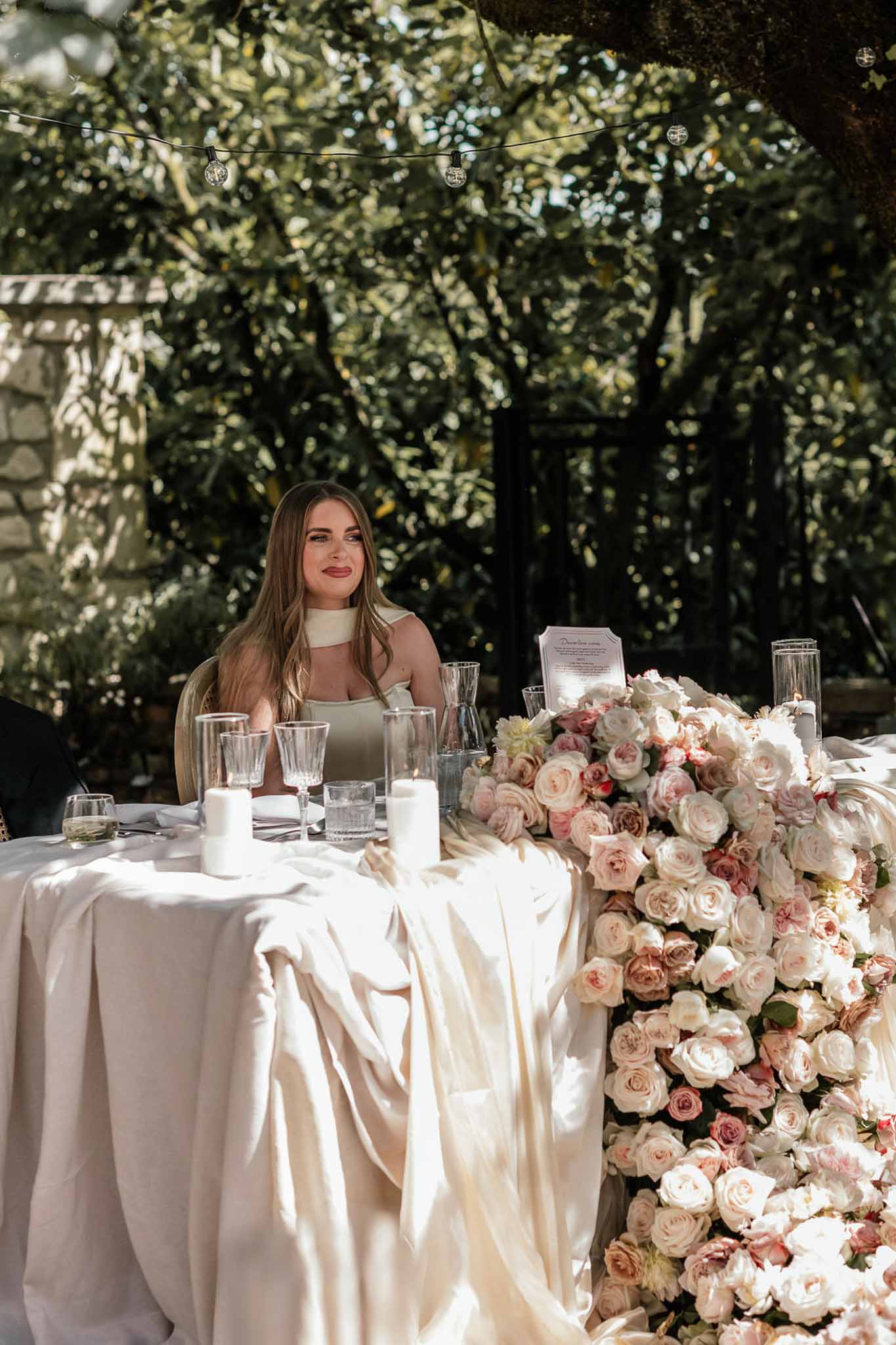 Wedding reception table setting in a garden with white roses