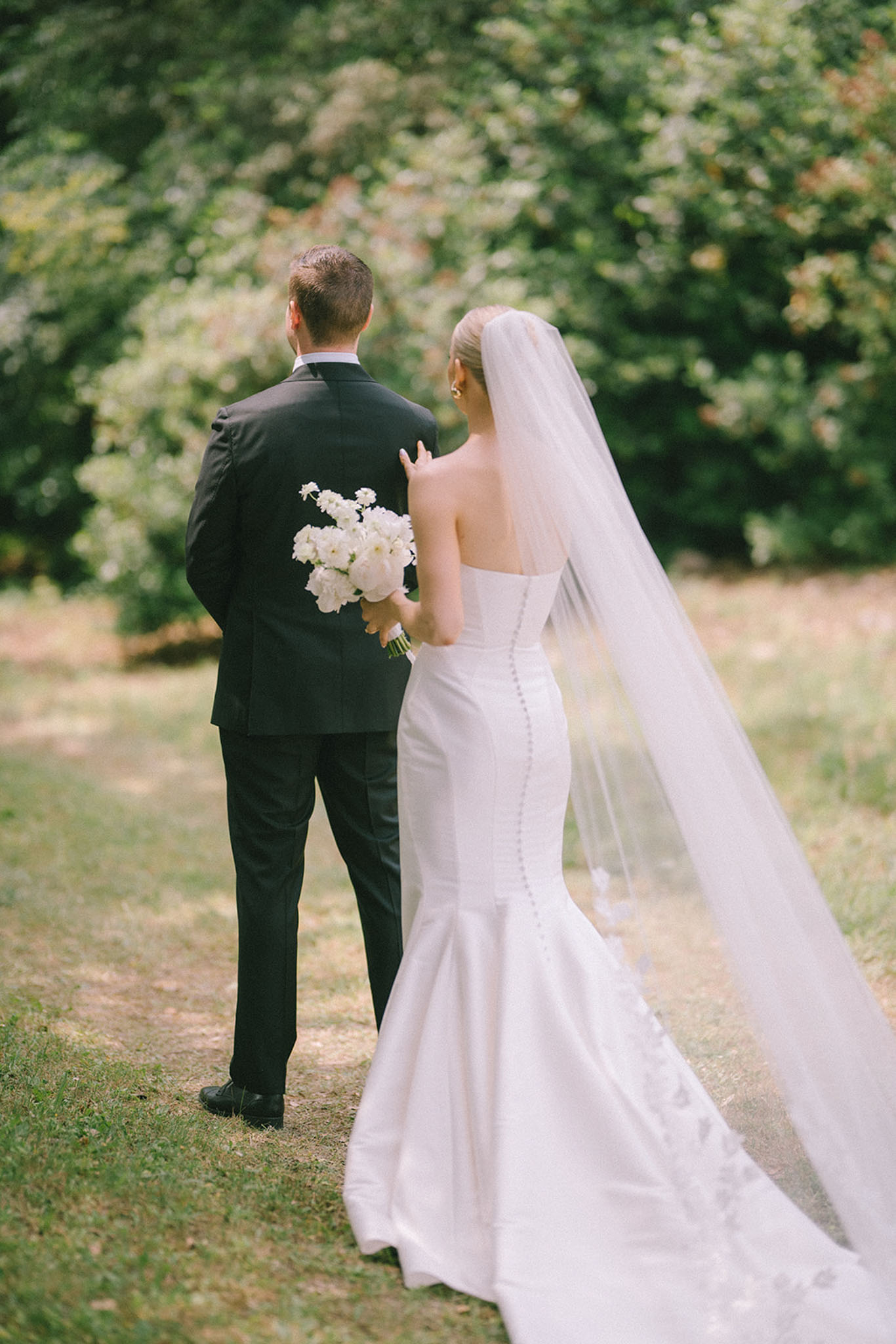 Bride and groom walking hand in hand in a garden