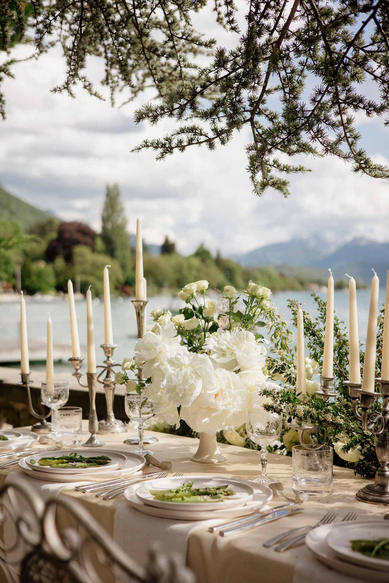 Lakeside reception table with white peony compote silver candelabras and champagne jacquard linen