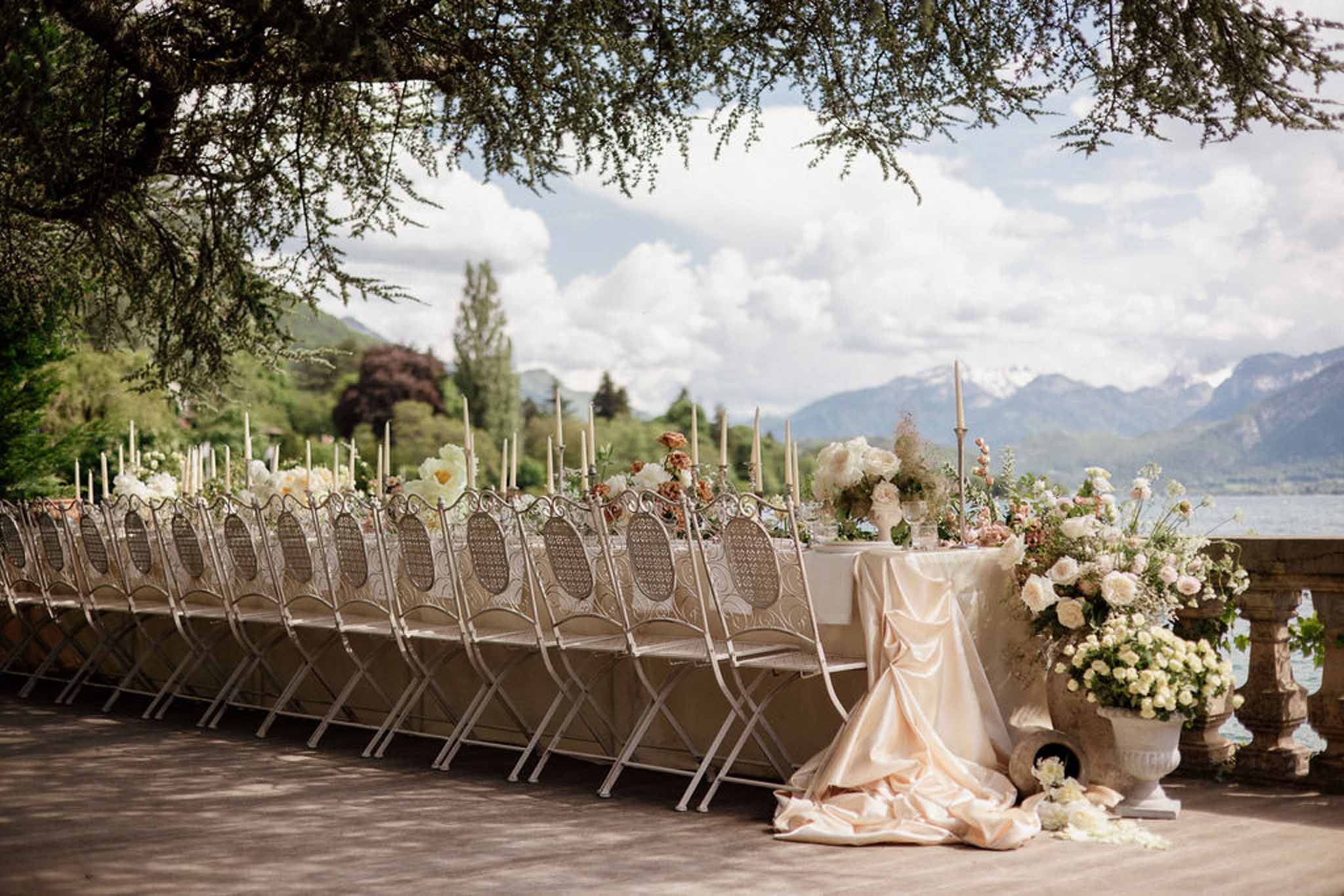 Lakeside reception table with blush satin linen ivory rose runner and mountain backdrop