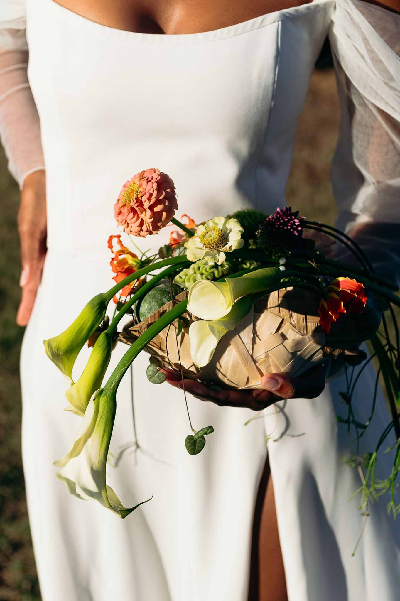 Bride holding woven basket bouquet with natural flowers, market-inspired bridal styling, Bastide des Barattes