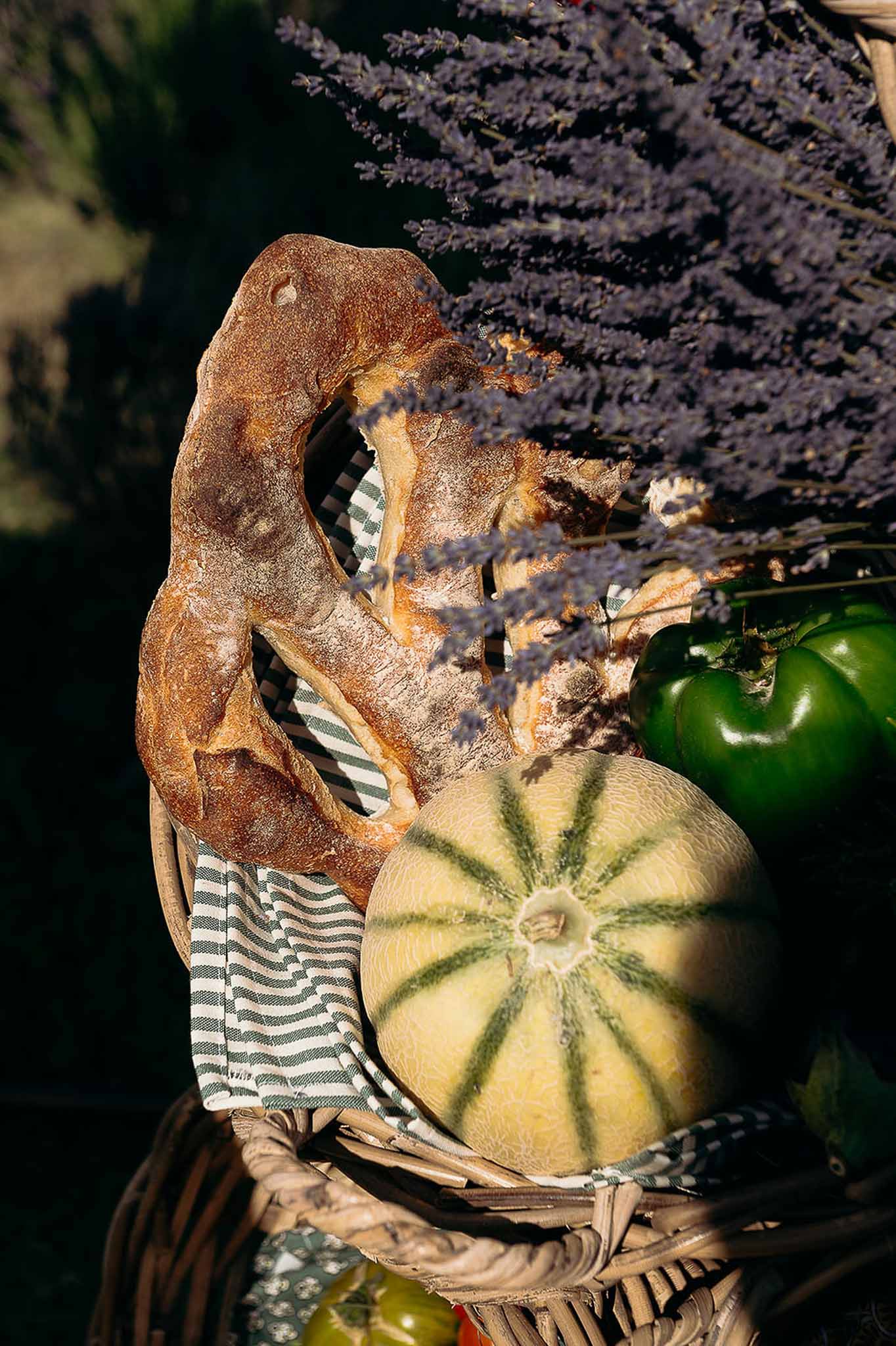 Close-up of bread, vegetables, basket and floral decor on the market reception table, Bastide des Barattes