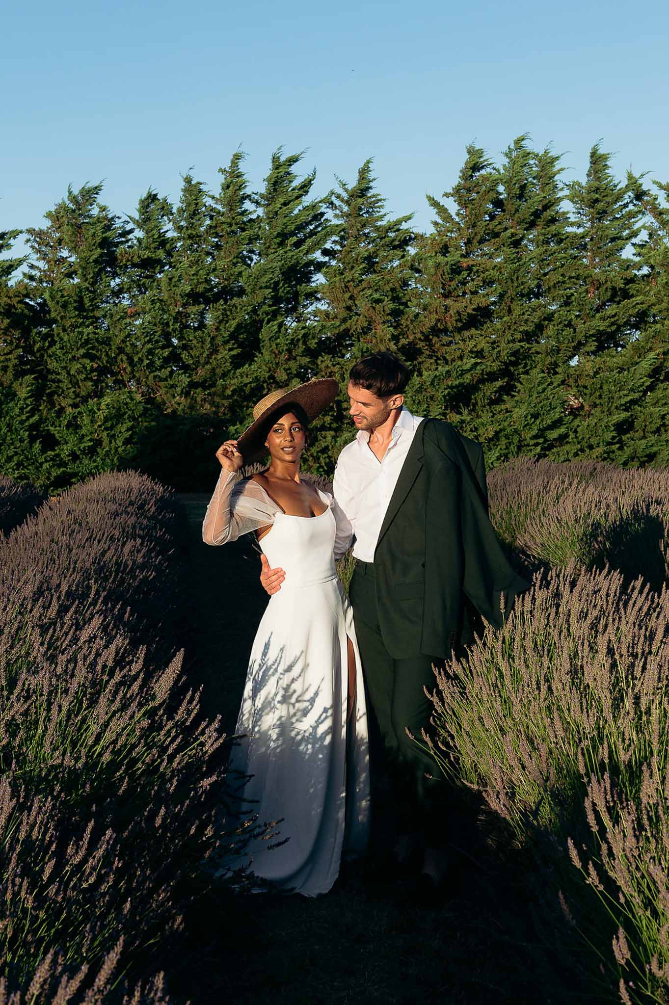 Bride and groom hugging among lavender rows at golden hour, romantic Provençal countryside