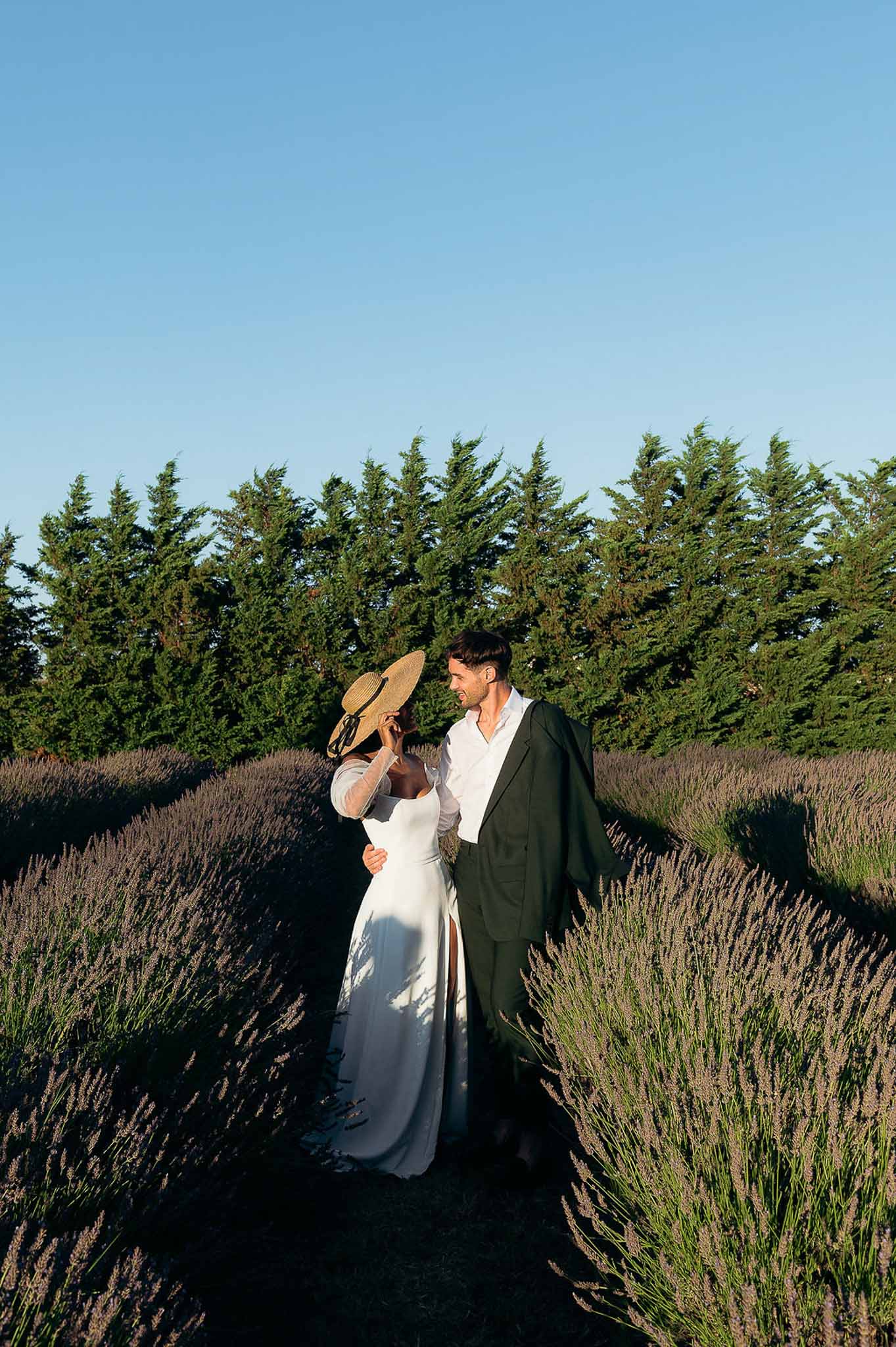 Bride and groom embracing in lavender fields at golden hour, Bastide des Barattes Luberon