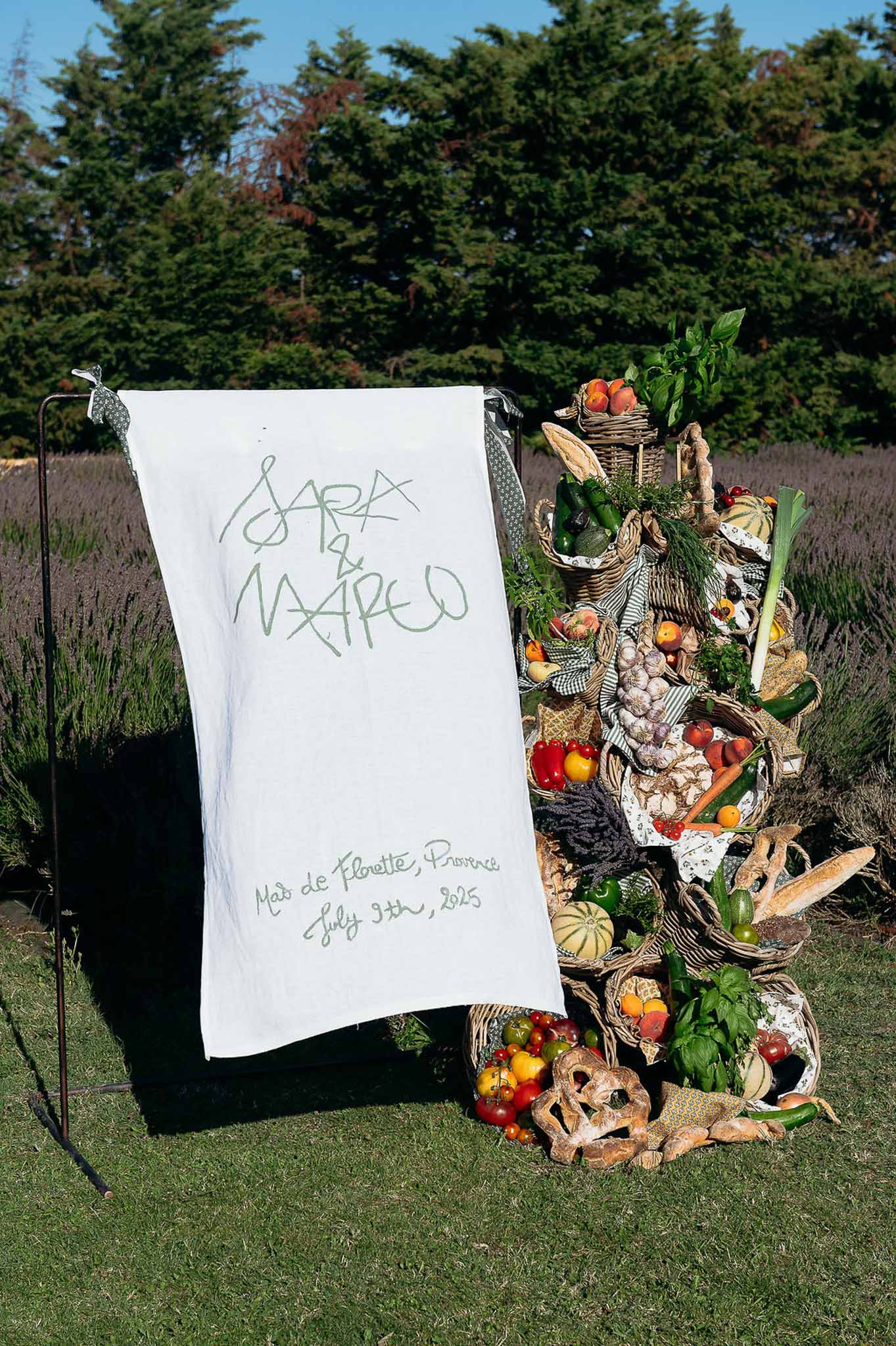 Hanging cloth signage with vegetable basket decor, market-themed wedding styling at Bastide des Barattes