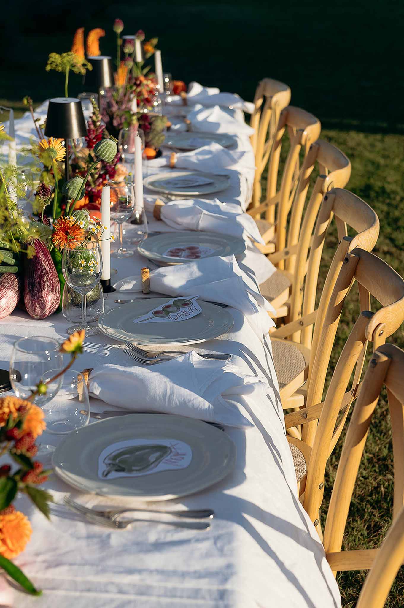 Golden hour tablescape with centerpiece and wooden chairs at Bastide des Barattes garden reception