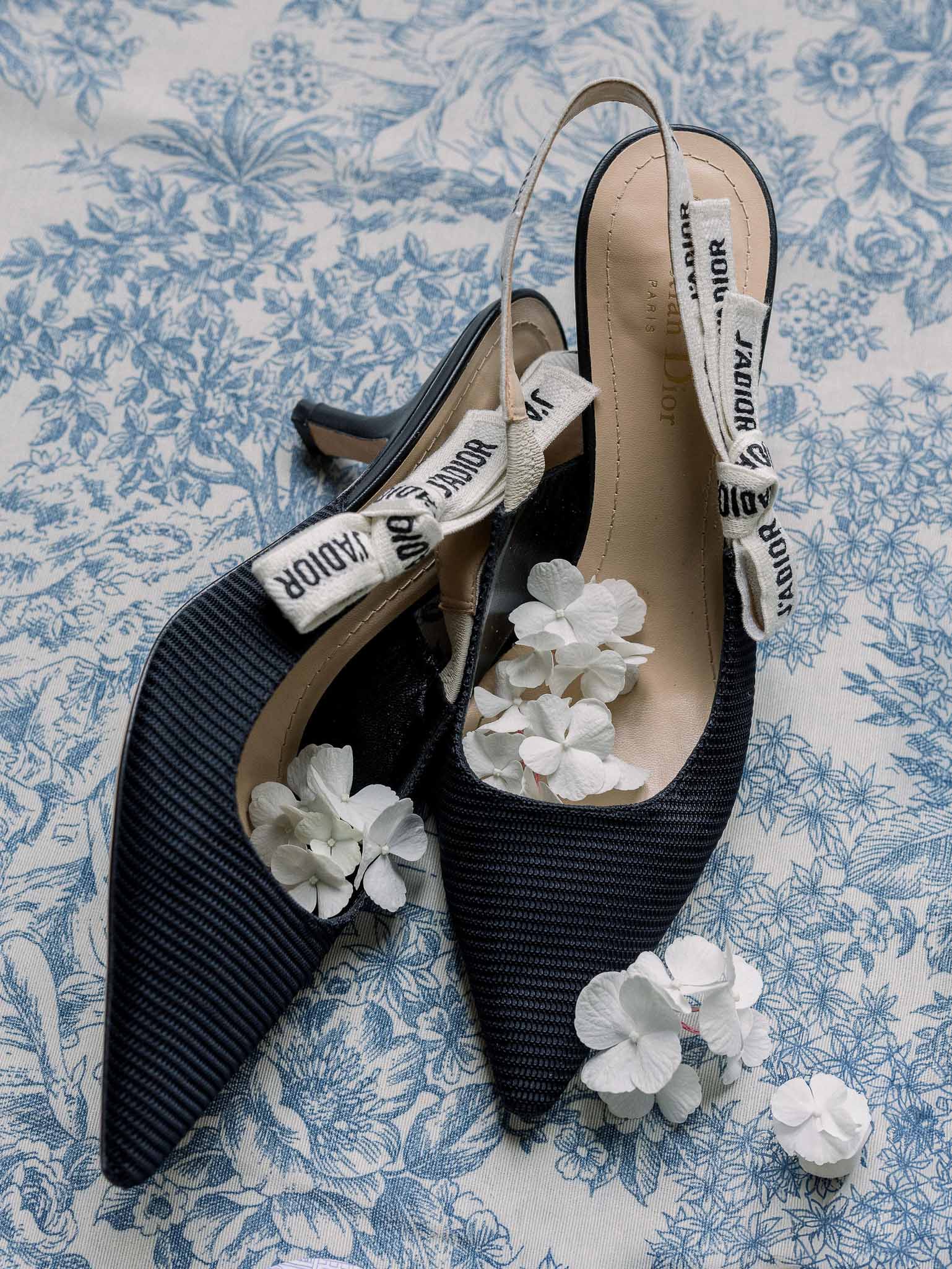 Navy Dior J'Adior slingback kitten heels with white hydrangea on toile de Jouy fabric