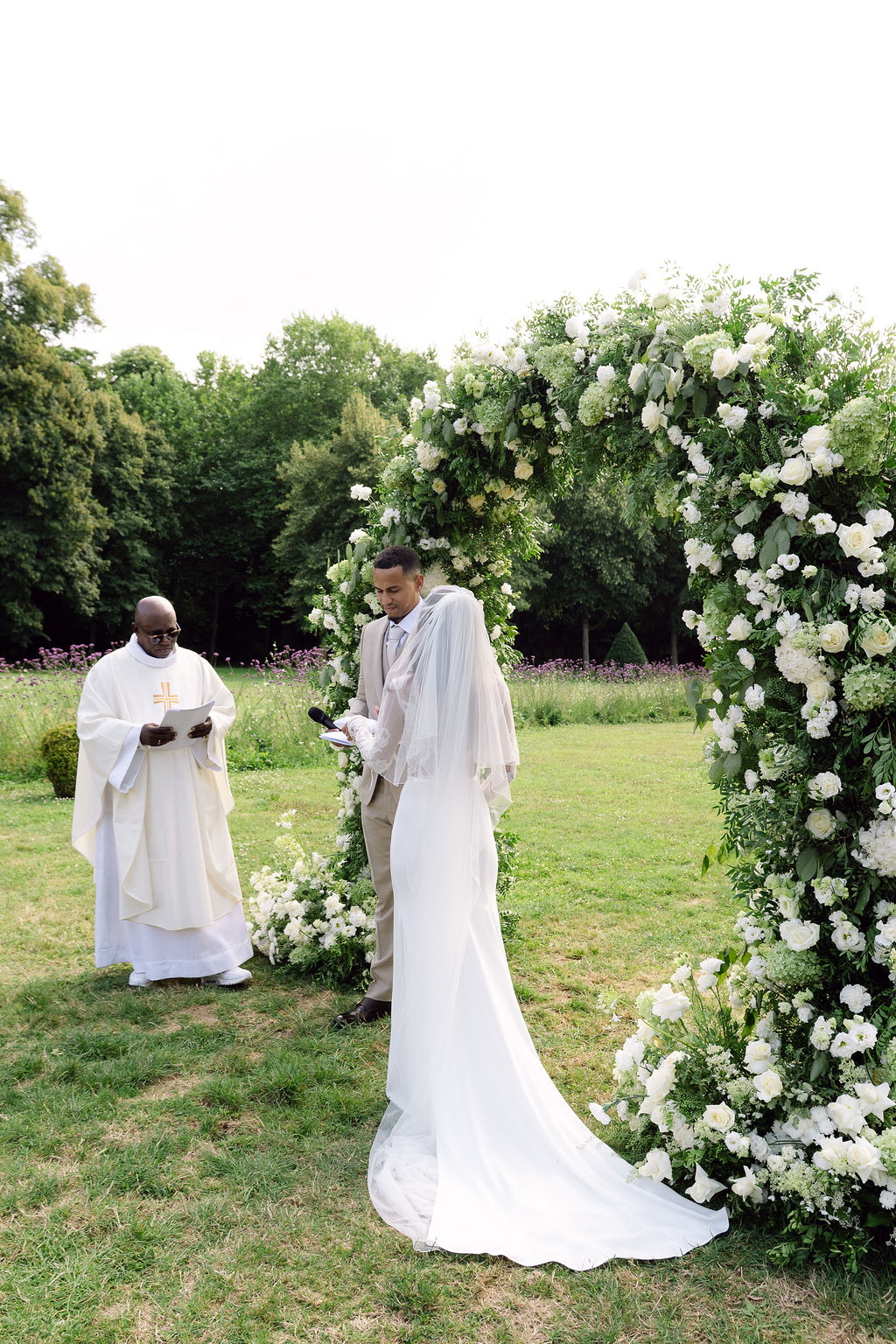 Couple exchanging vows in a garden with white roses