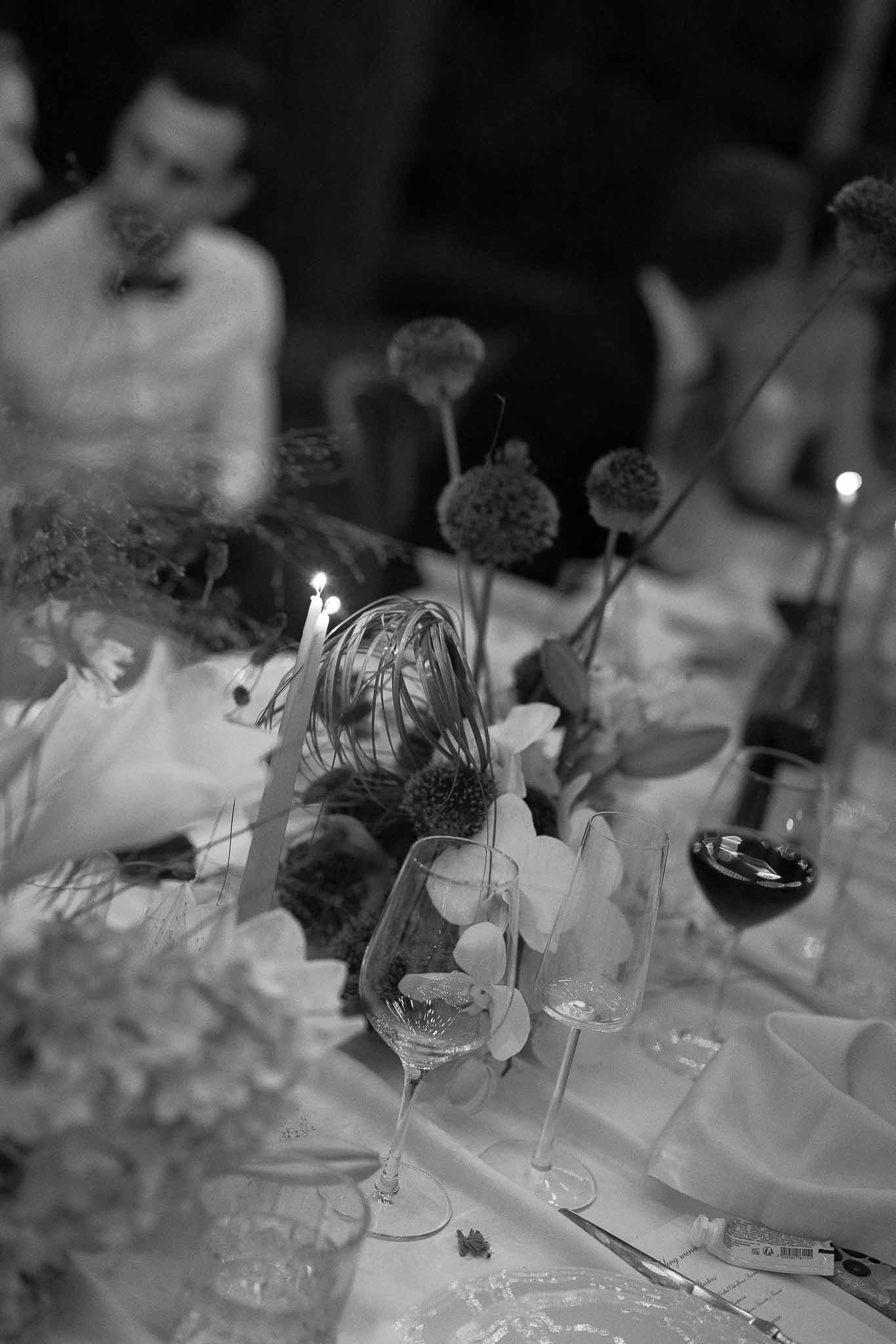 Black and white photo of wedding reception table setting with white roses