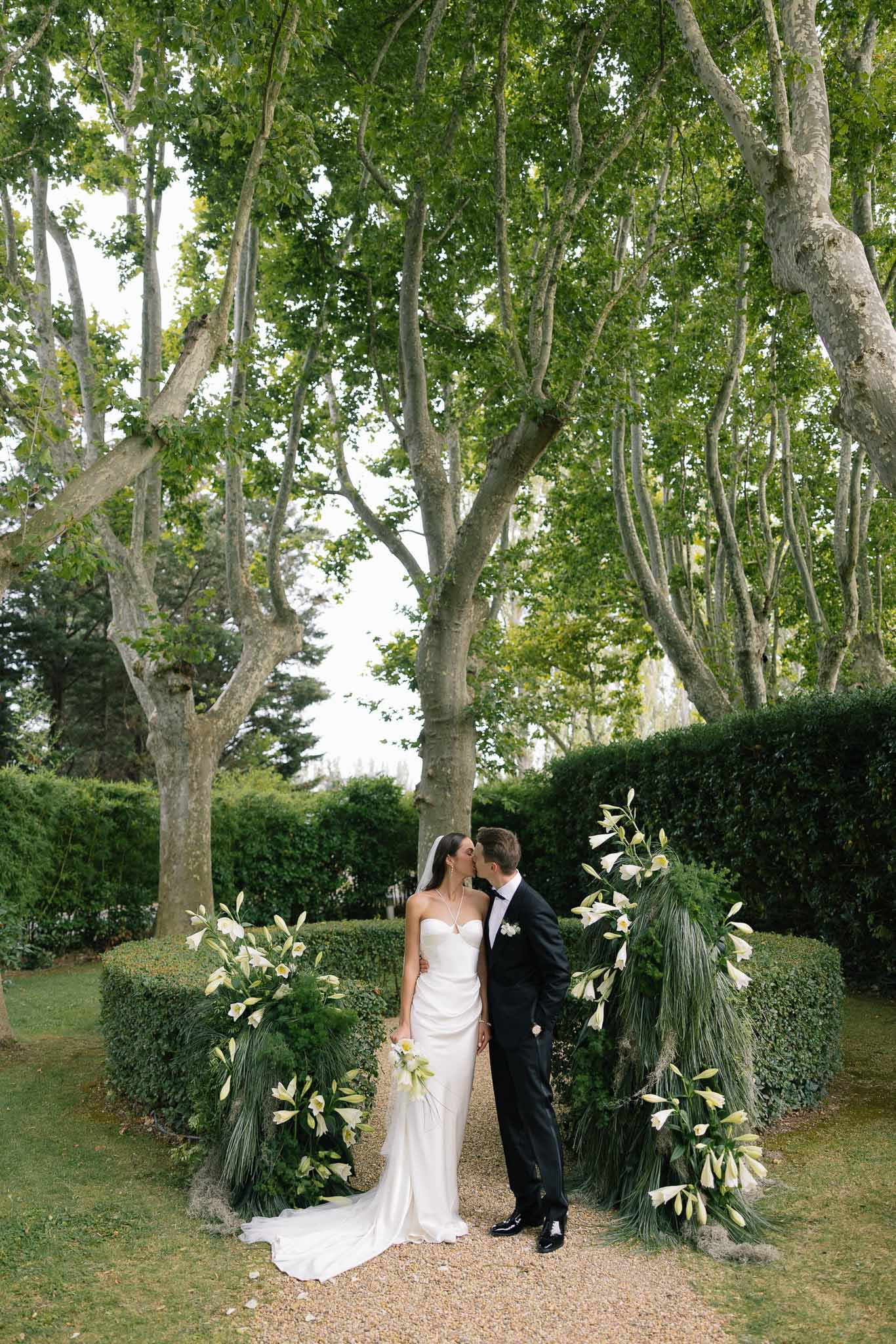 Bride and groom kissing in a garden