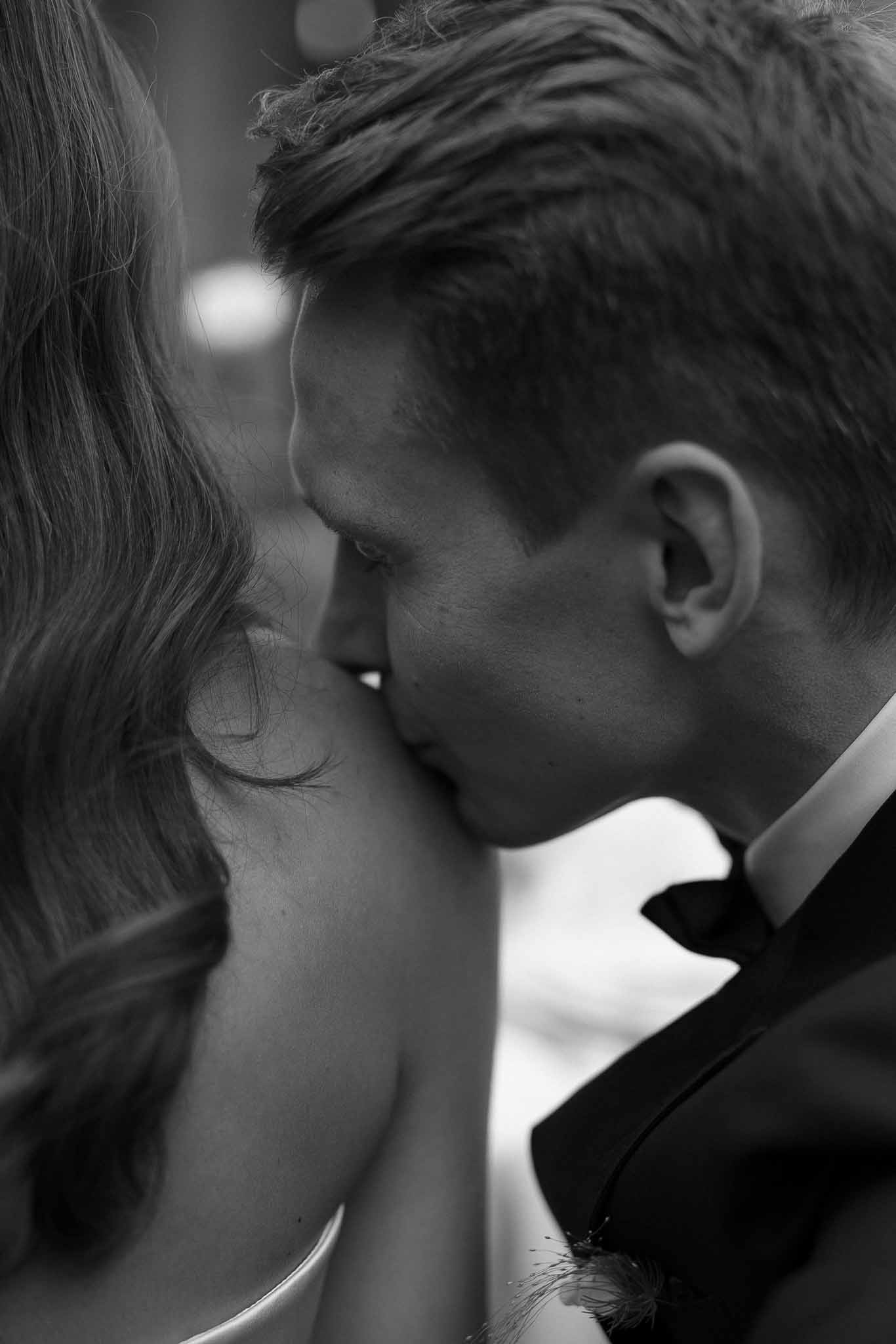 Black and white photo of bride and groom kissing