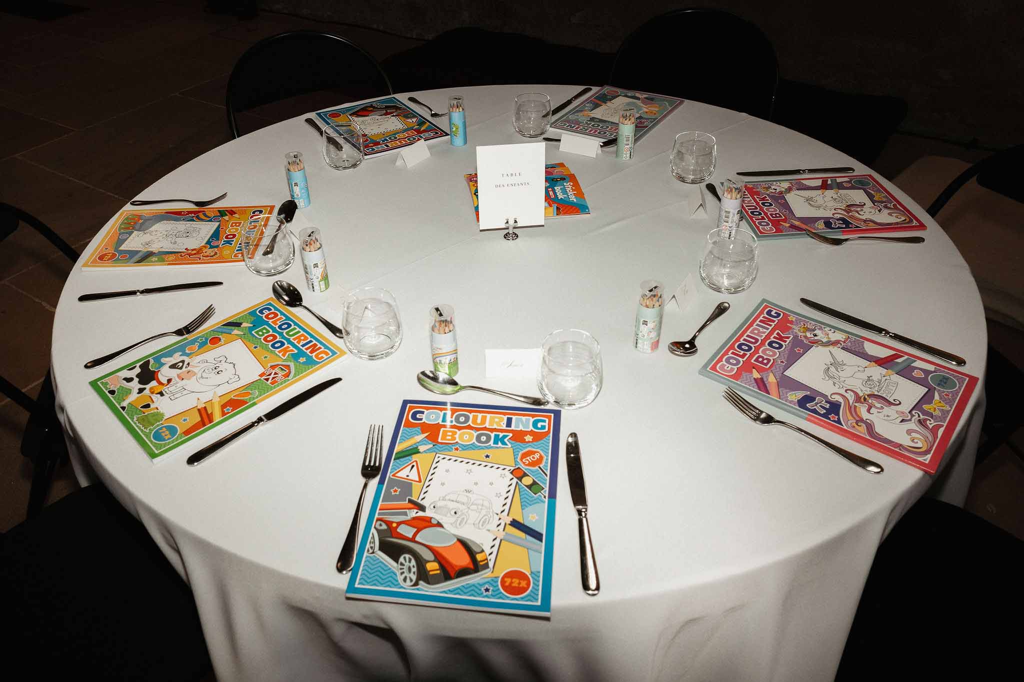 Children's table at wedding reception with colouring books, coloured pencils, and Table des Enfants sign